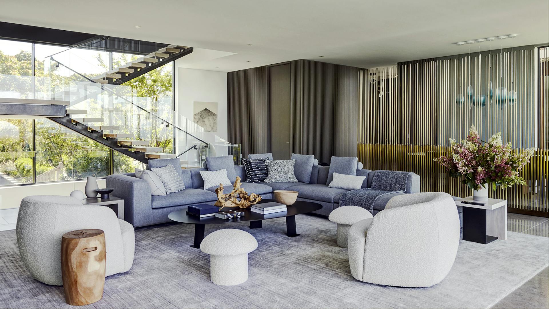 Bay House living room against a glass stair and bronze screen