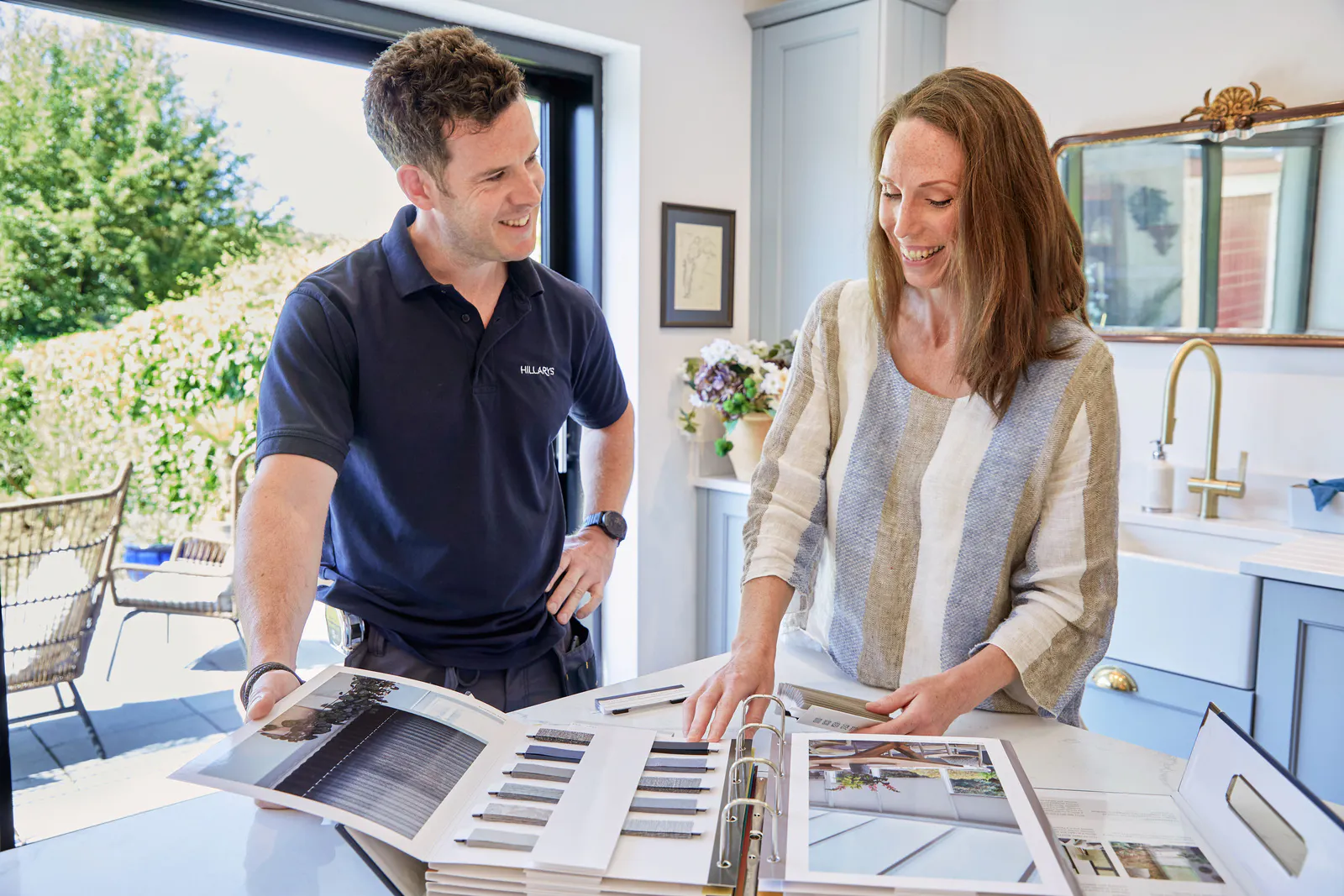 Friendly Hillarys advisor consulting a customer at their home and showing samples