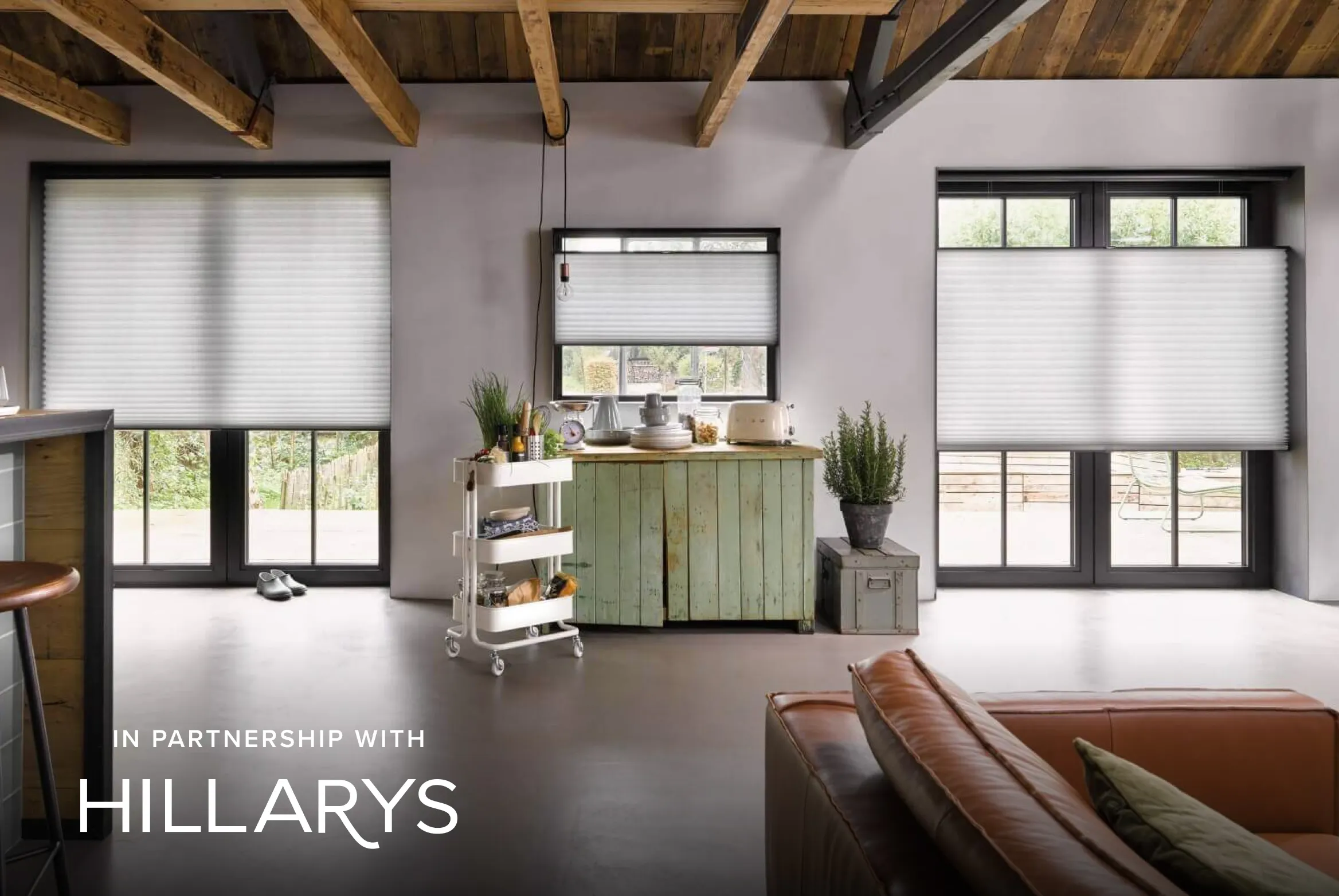 White Duette® honeycomb blinds on patio doors and windows in a rustic open‑plan living space.