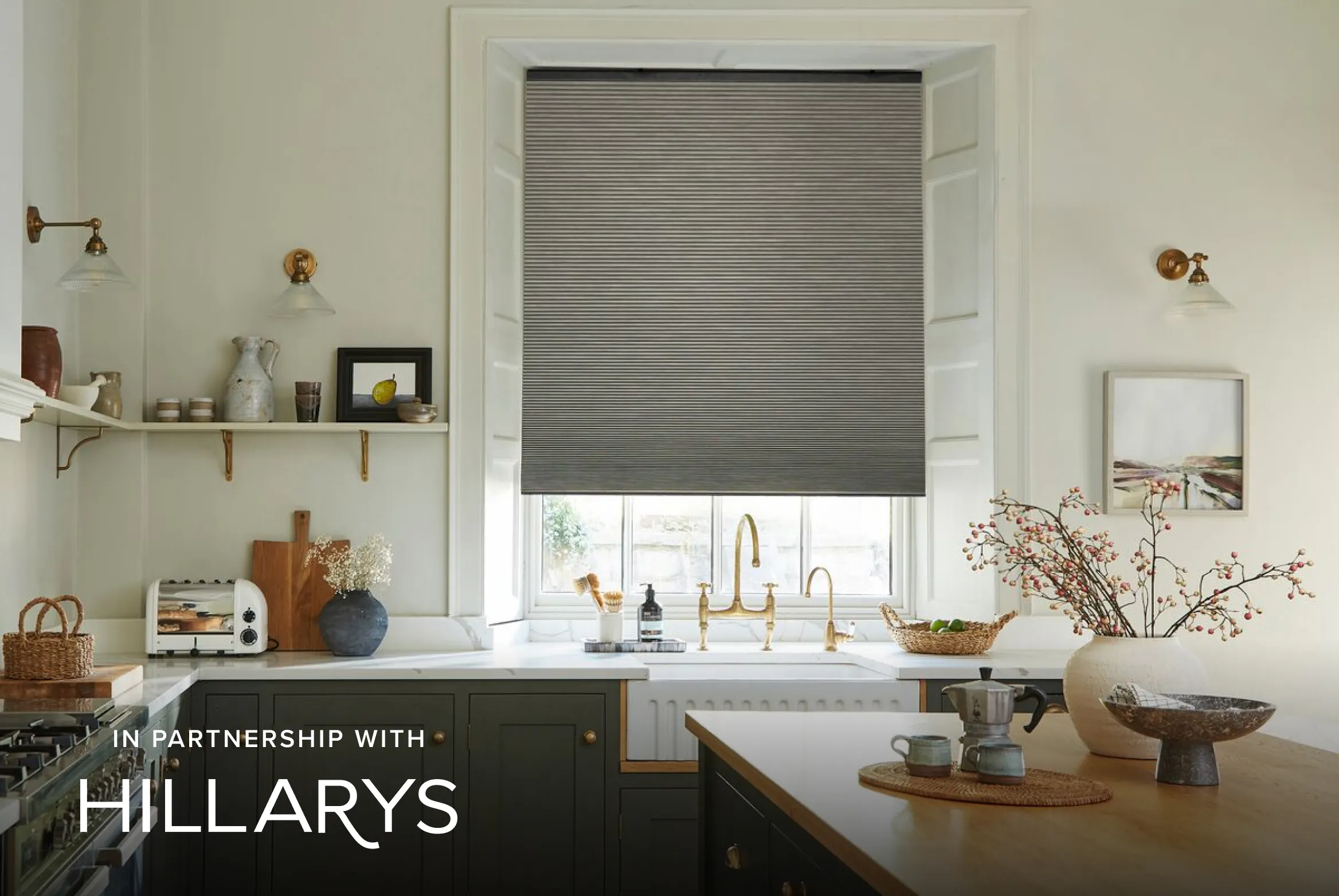 Grey half-closed Duette® honeycomb blinds on a window in a cosy kitchen