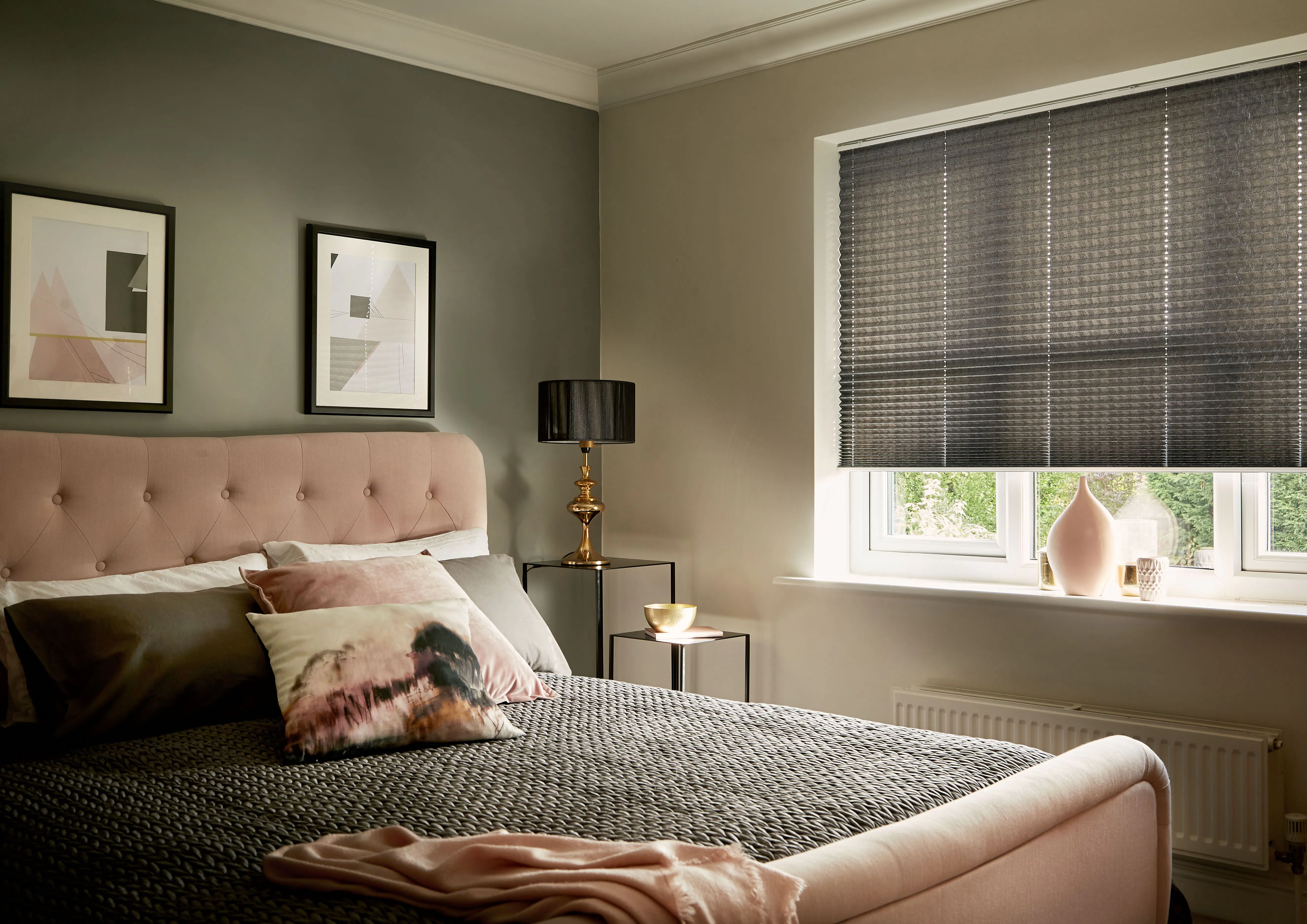 Brown half-closed Duette® honeycomb blinds on a window in a luxurious bedroom