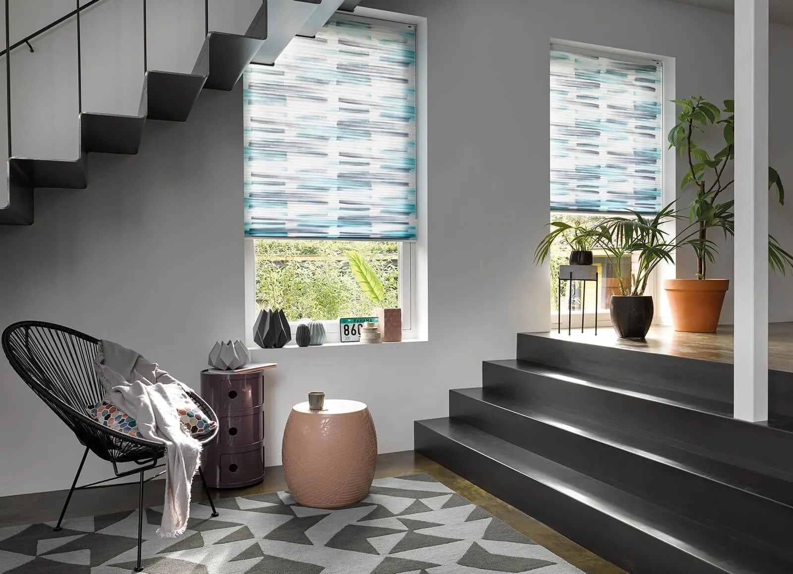 Patterned blue Duette® honeycomb blinds on two windows in a stylish modern hallway.