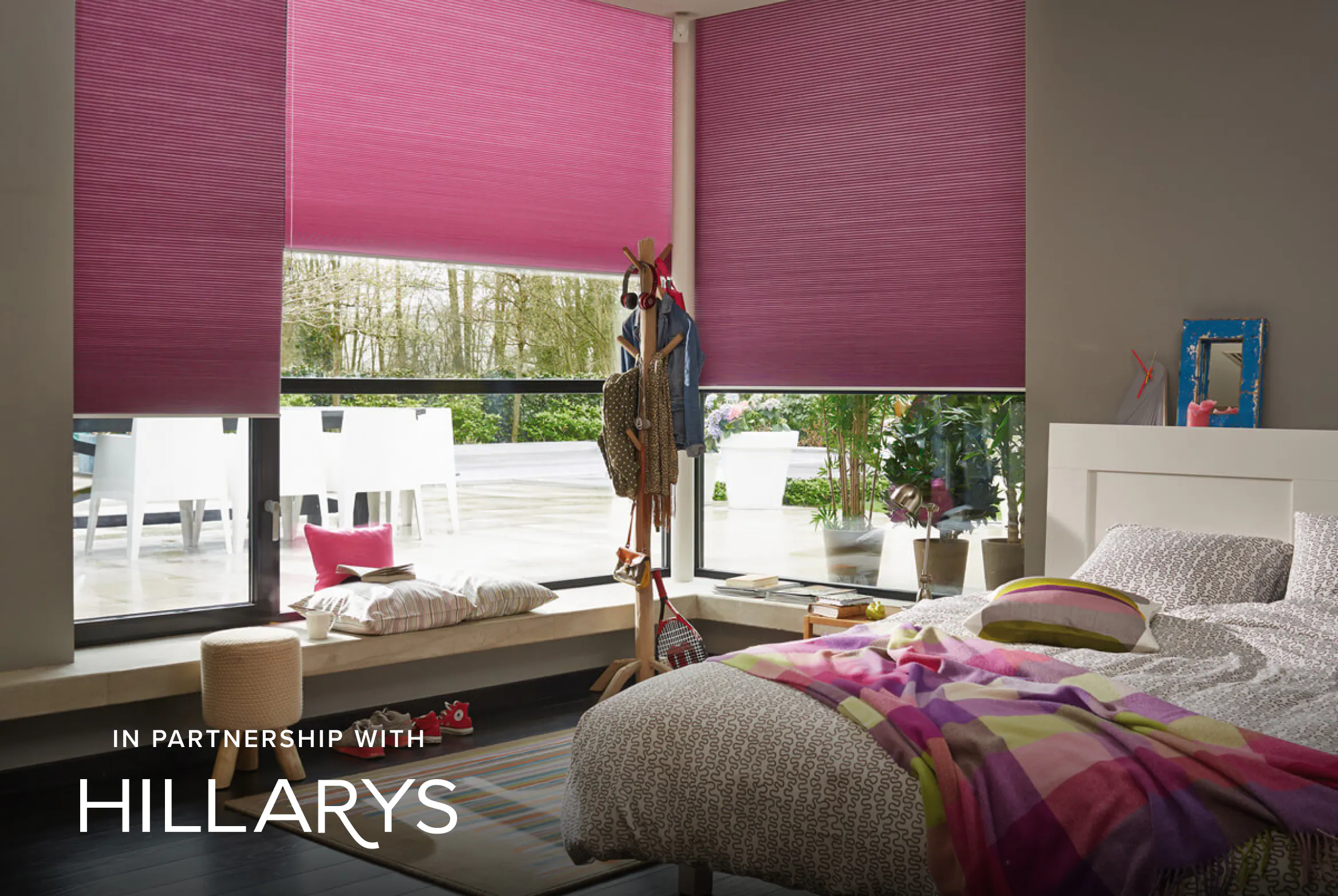 Pink Duette® blinds on large windows in a vibrant bedroom