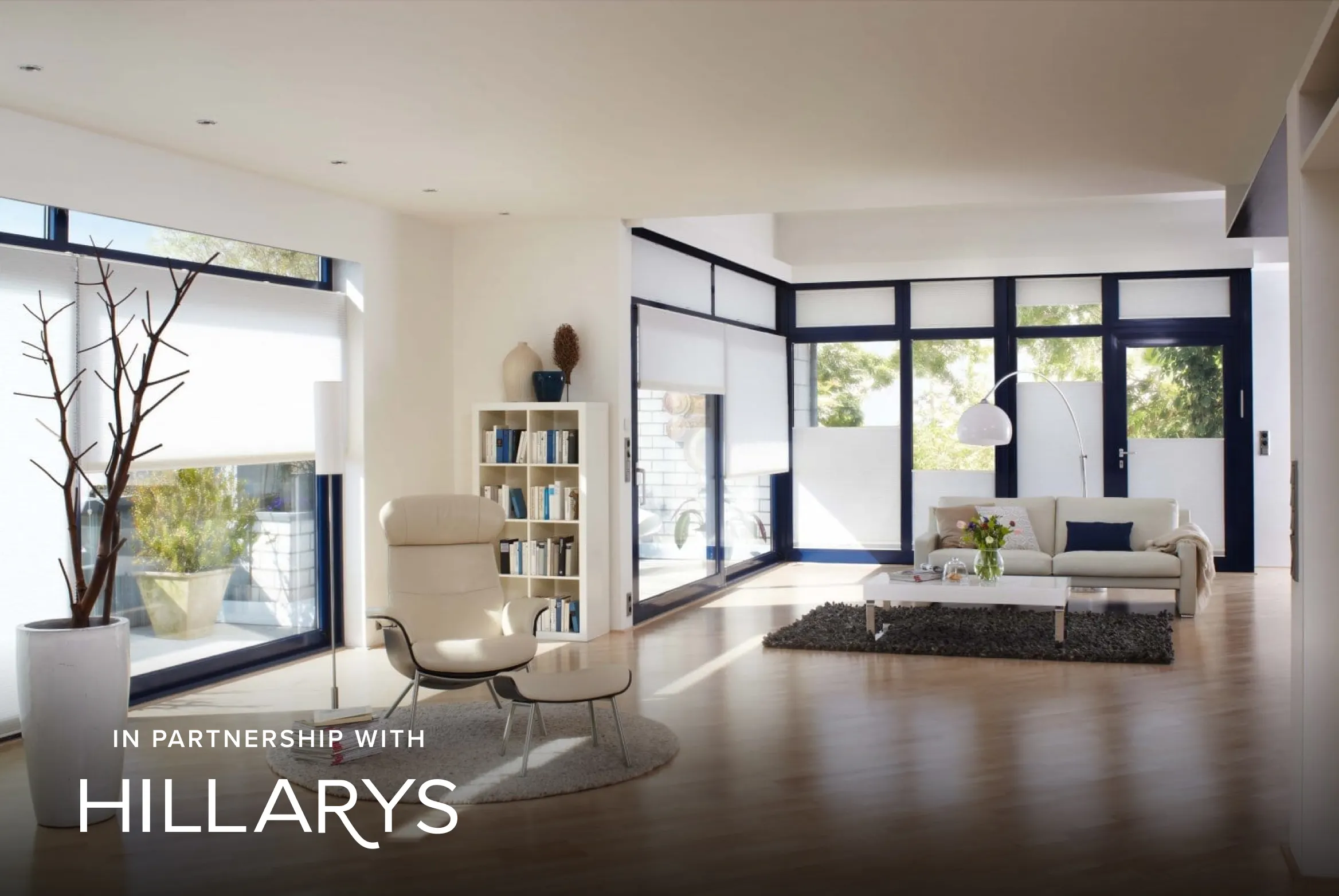 Large windows and patio doors with white Duette® honeycomb blinds in a modern living space with contemporary furniture.