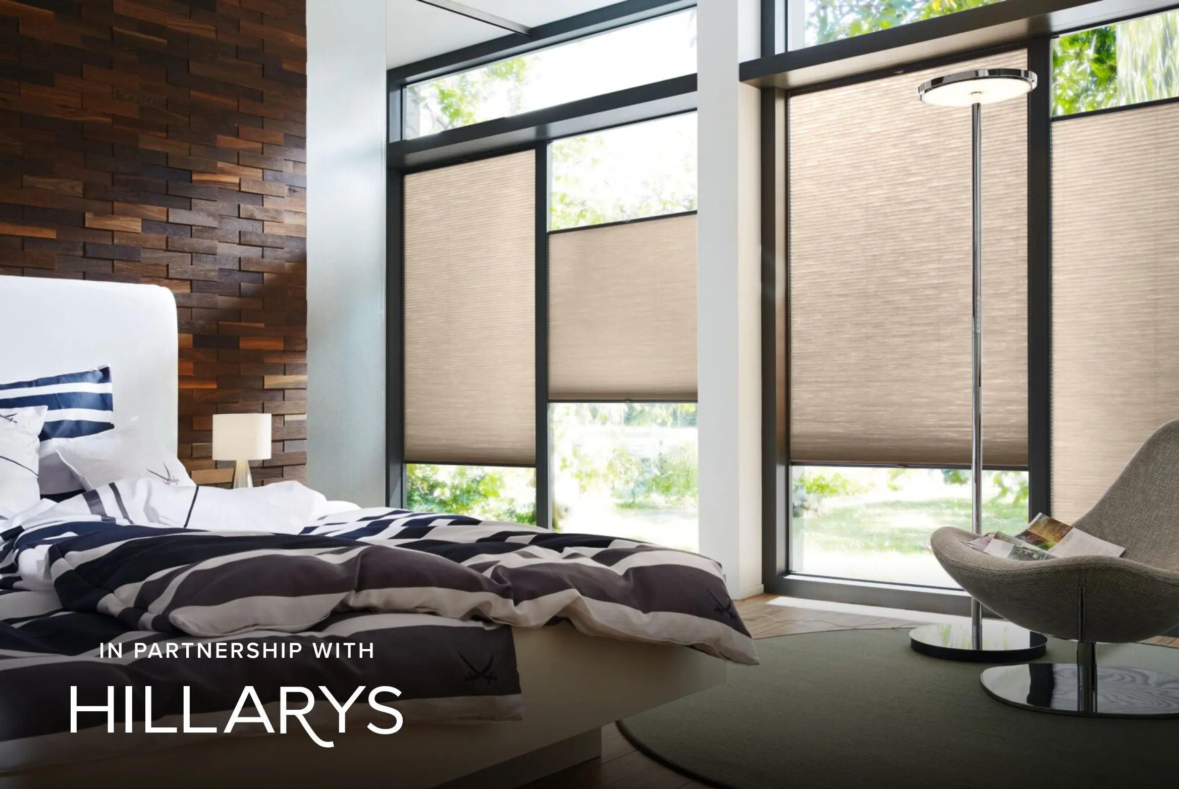 Beige Duette® honeycomb blinds on large windows in a light bedroom