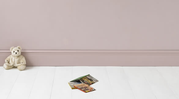White teddy bear in front of a pink pastel wall