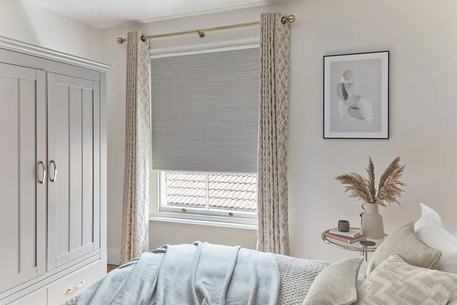 Light grey Duette® honeycomb blinds in a light bedroom