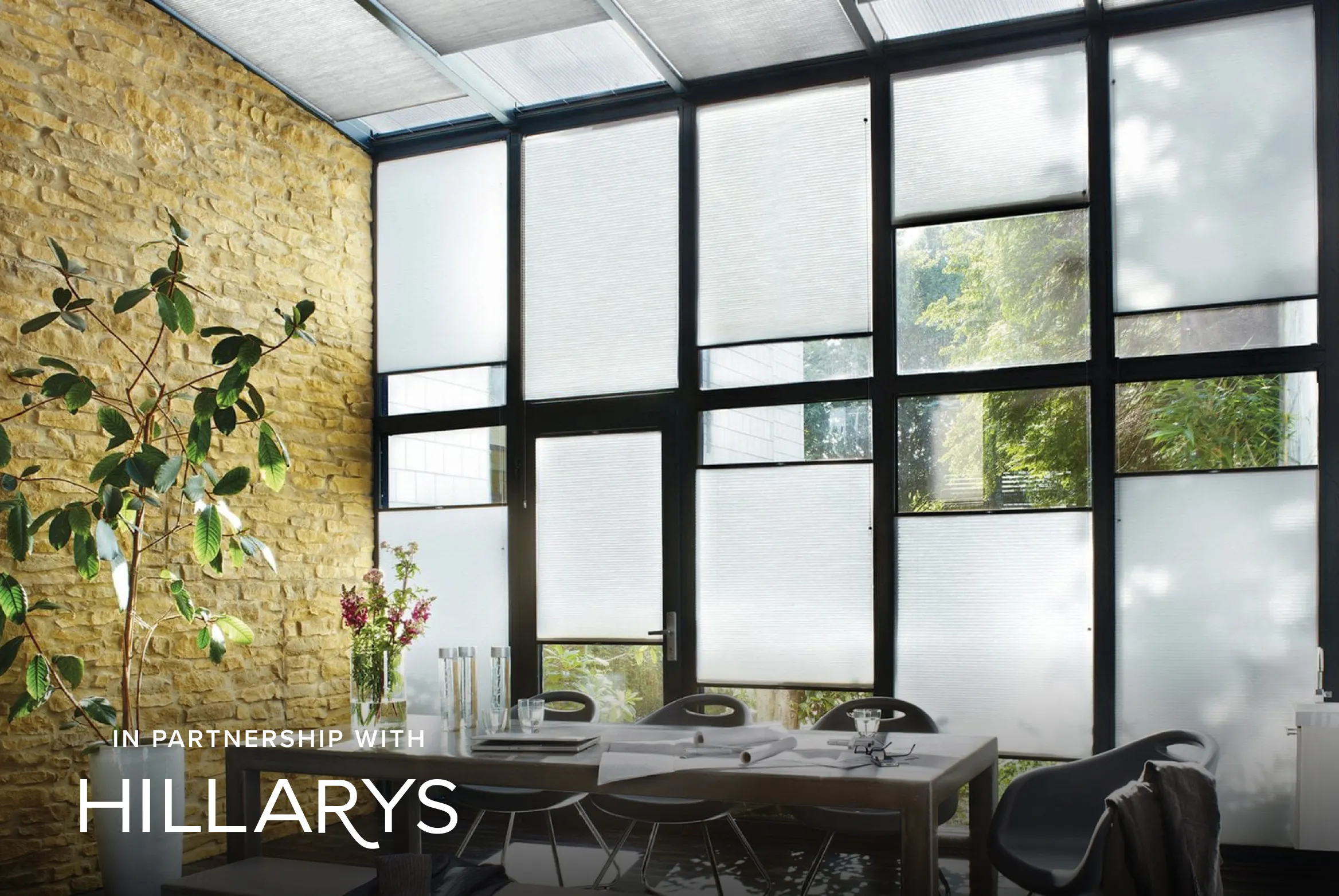 Light grey Duette® honeycomb blinds on tall conservatory windows enhancing privacy and energy efficiency.