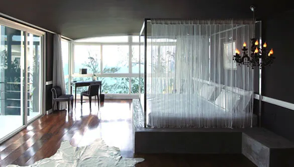 Modern cosy bedroom with luxurious voile curtains around the bed