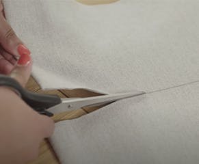 4. Use a craft knife or sharp pair of scissors to carefully cut the fabric, and a hacksaw to trim the bottom bar.