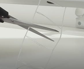 9. Remove the base rail and surplus slats, cut off the excess ladder tape while ensuring 35mm surplus remains. Replace the base rail, rethread the lift cord and retie the knot in the end of the cord.