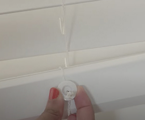 8. To reduce the blind drop, fully lower the blind, remove the buttons in the base rail and untie the knot in the lift cord.