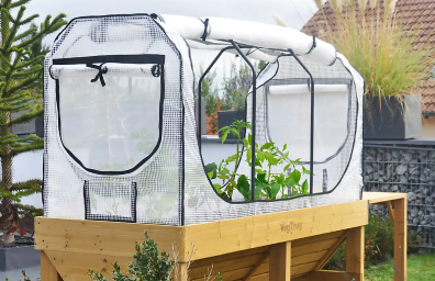 A portable greenhouse with a green fabric top, designed for outdoor use.