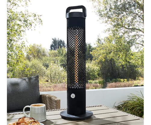 An outdoor heater placed on a table, providing warmth for an outdoor seating area.