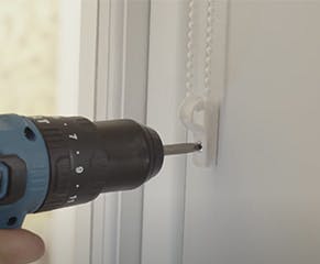 9. Lastly, to install the cord tensioning child safety device - also called a P-Clip - clip the device to the blind cord and make a pencil mark where to drill the hole. This should be at least 1.5m above the floor, and the cord should have continuous tension but still be able to run through the device. For cordless roller blinds you can skip this step as the blinds are by design and do not require a child safety device.