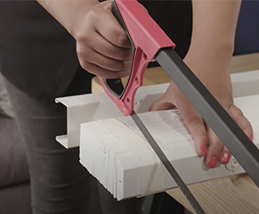 3. With the blind fully raised, tightly bind both ends of the slats and bottom rail with low adhesive tape. Make a mark where you need to cut. (note: The headrail should not be bound) And, using a hacksaw, carefully cut through the headrail, slats and bottom rail, repeating on the opposite end.