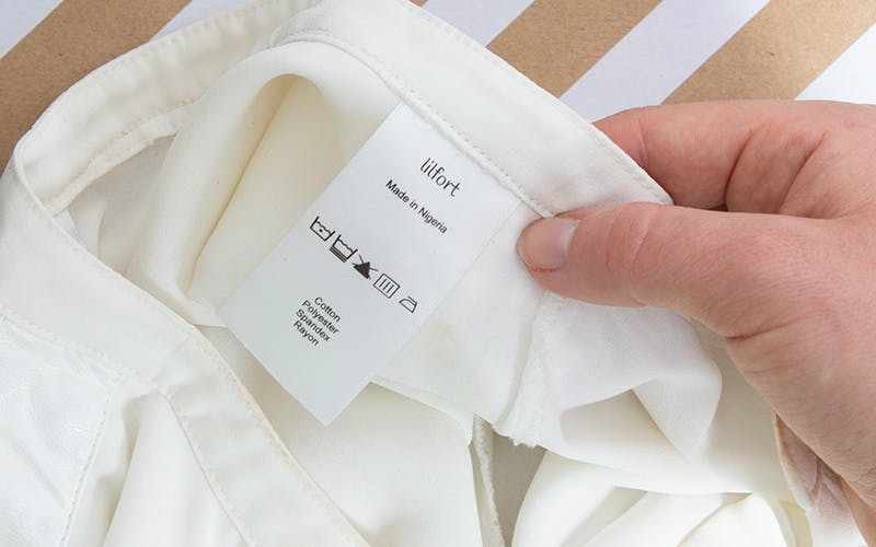  A woman inspecting the care label on a garment