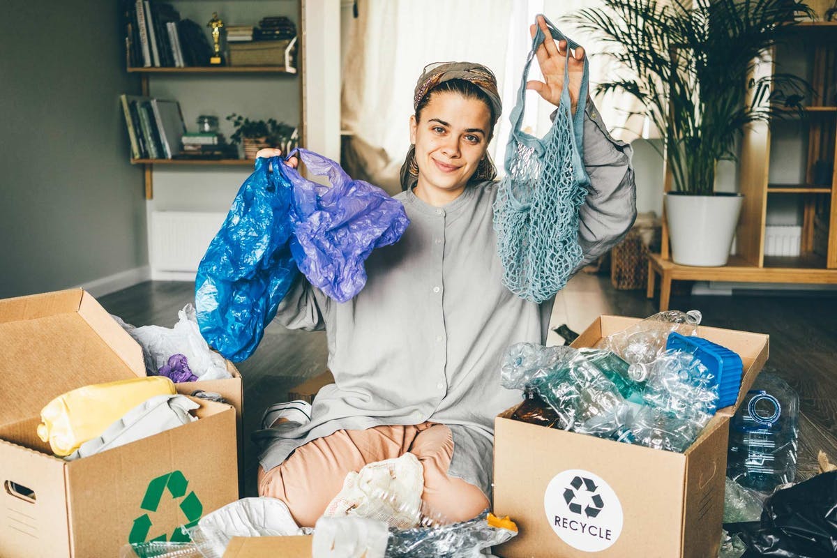  Mujer organiza plásticos y artículos reciclables en bolsas reutilizables
