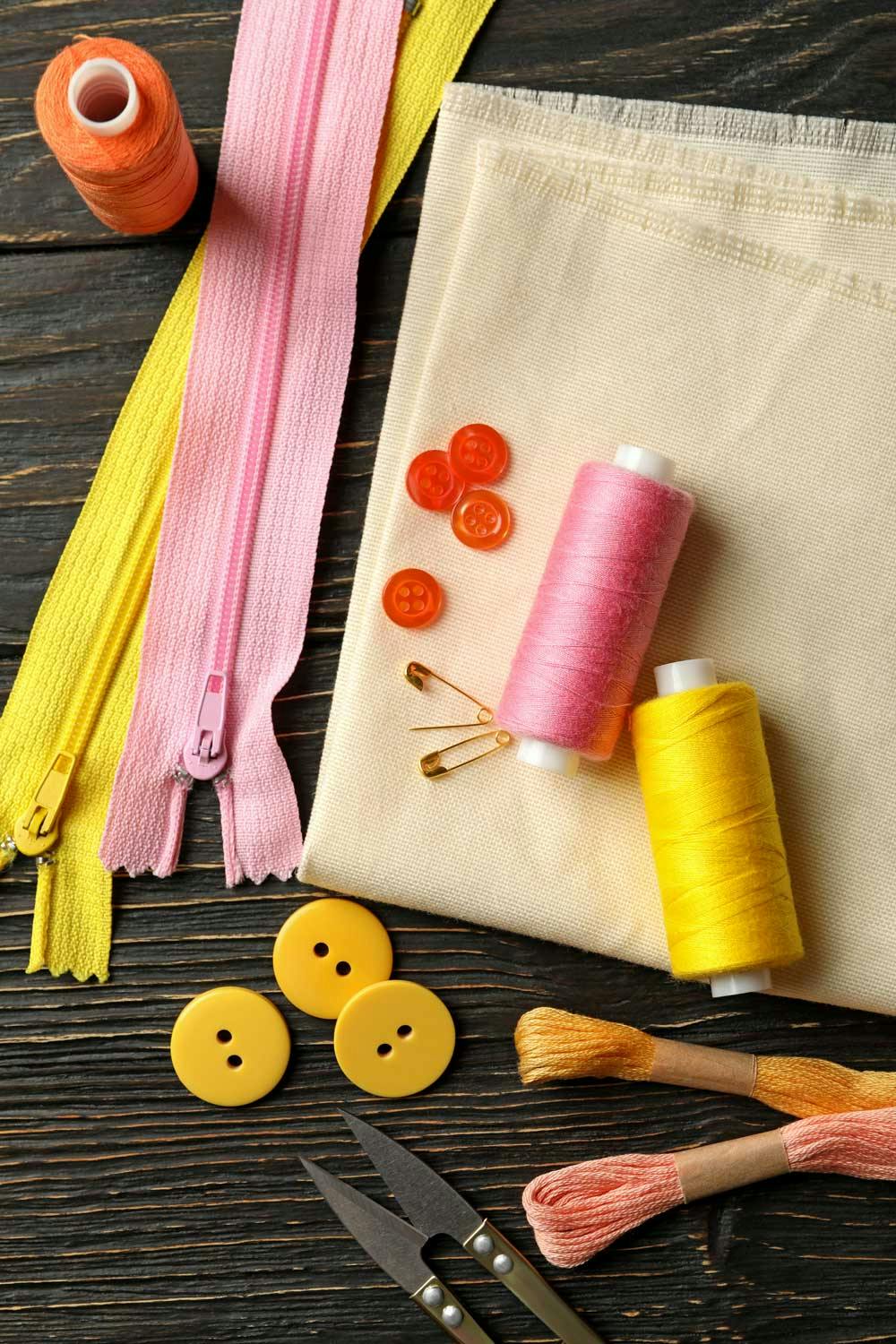  close up of sewing supplies like zips buttons and thread