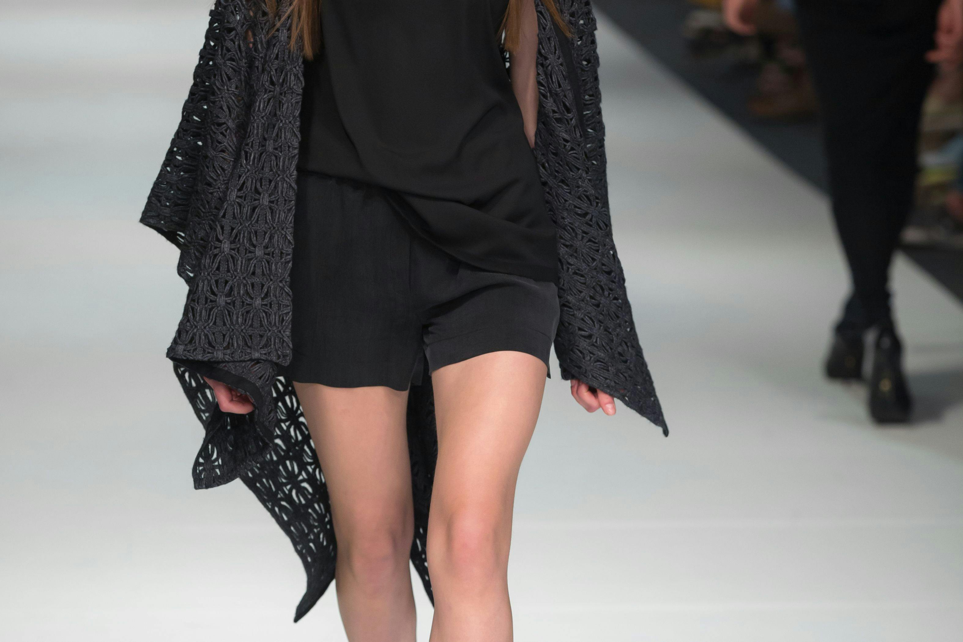  close up details of a woman walking on a fashion runway