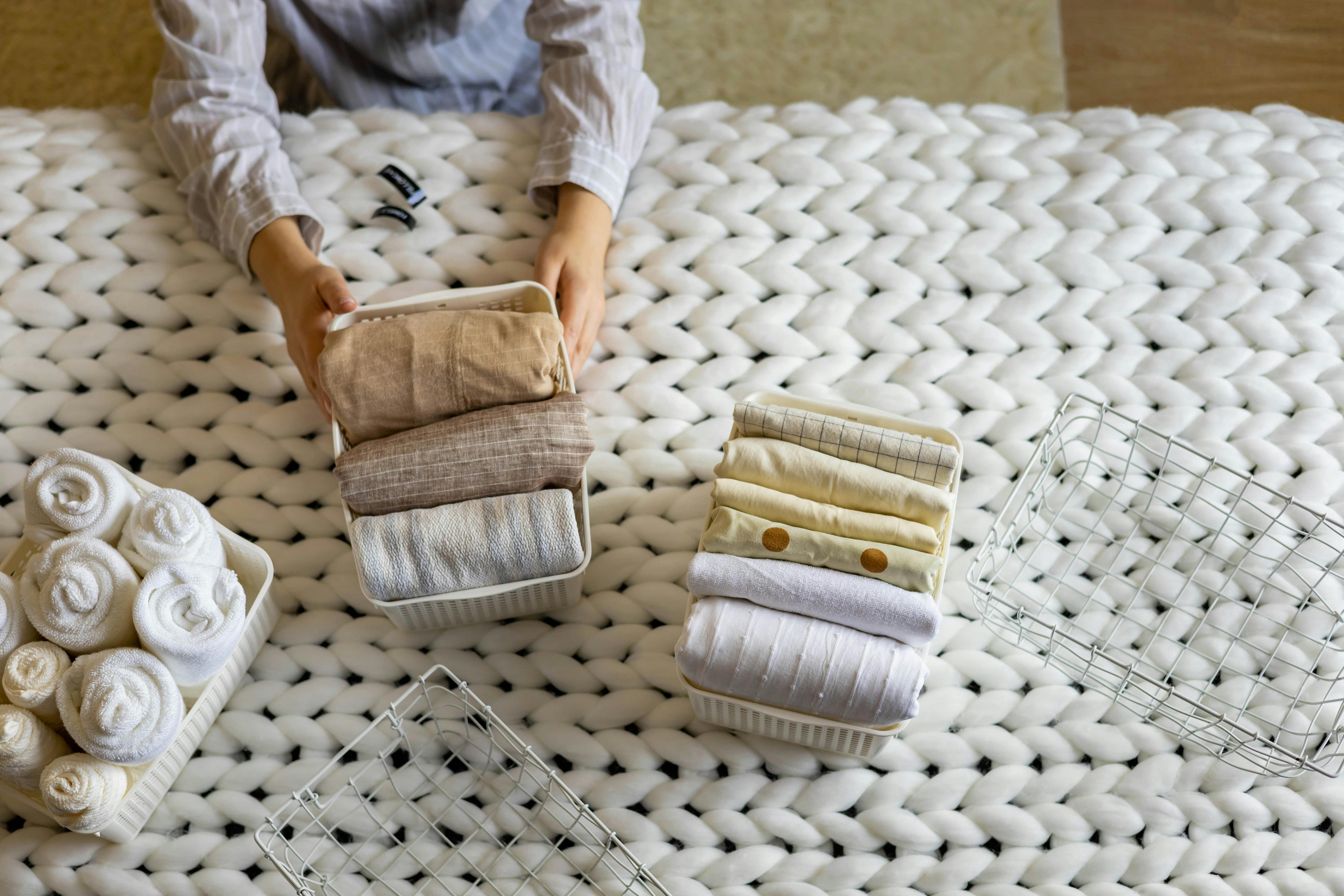  Hands neatly folding clothing into baskets