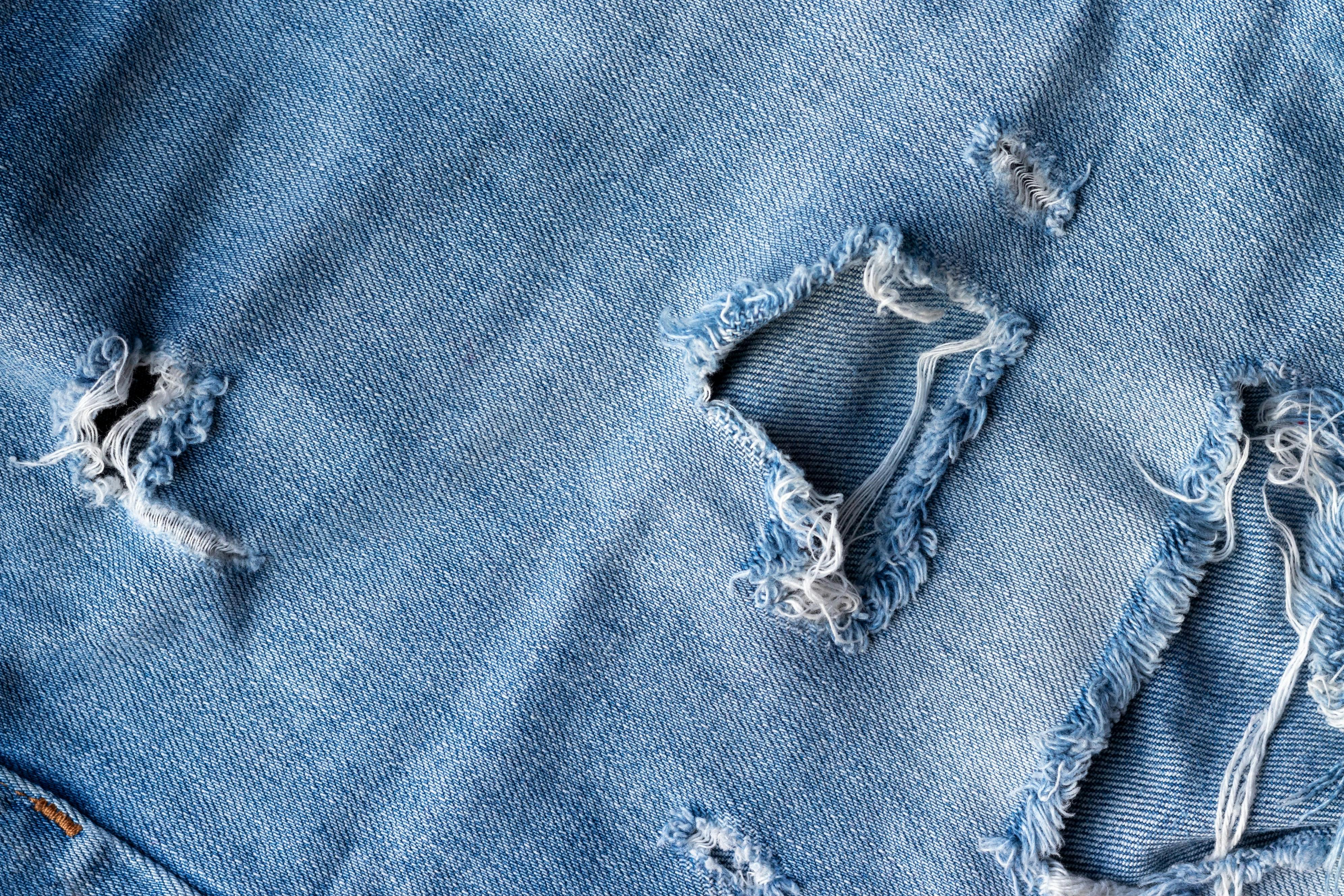 close up photograph of distressed blue jeans