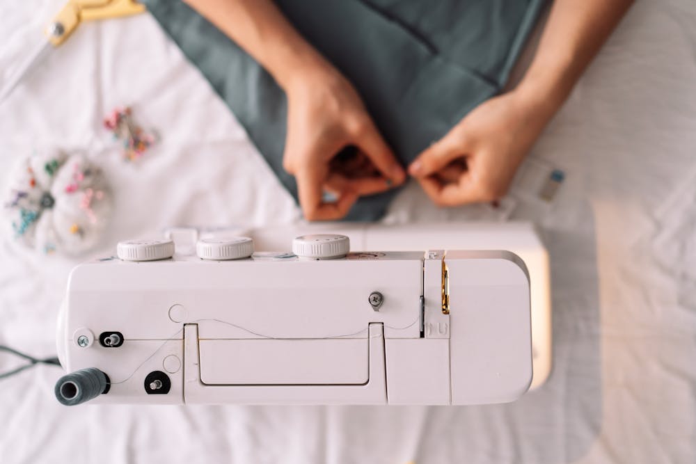 Overhead photo of hands at a sewing machine Overhead photo of hands at a sewing machine