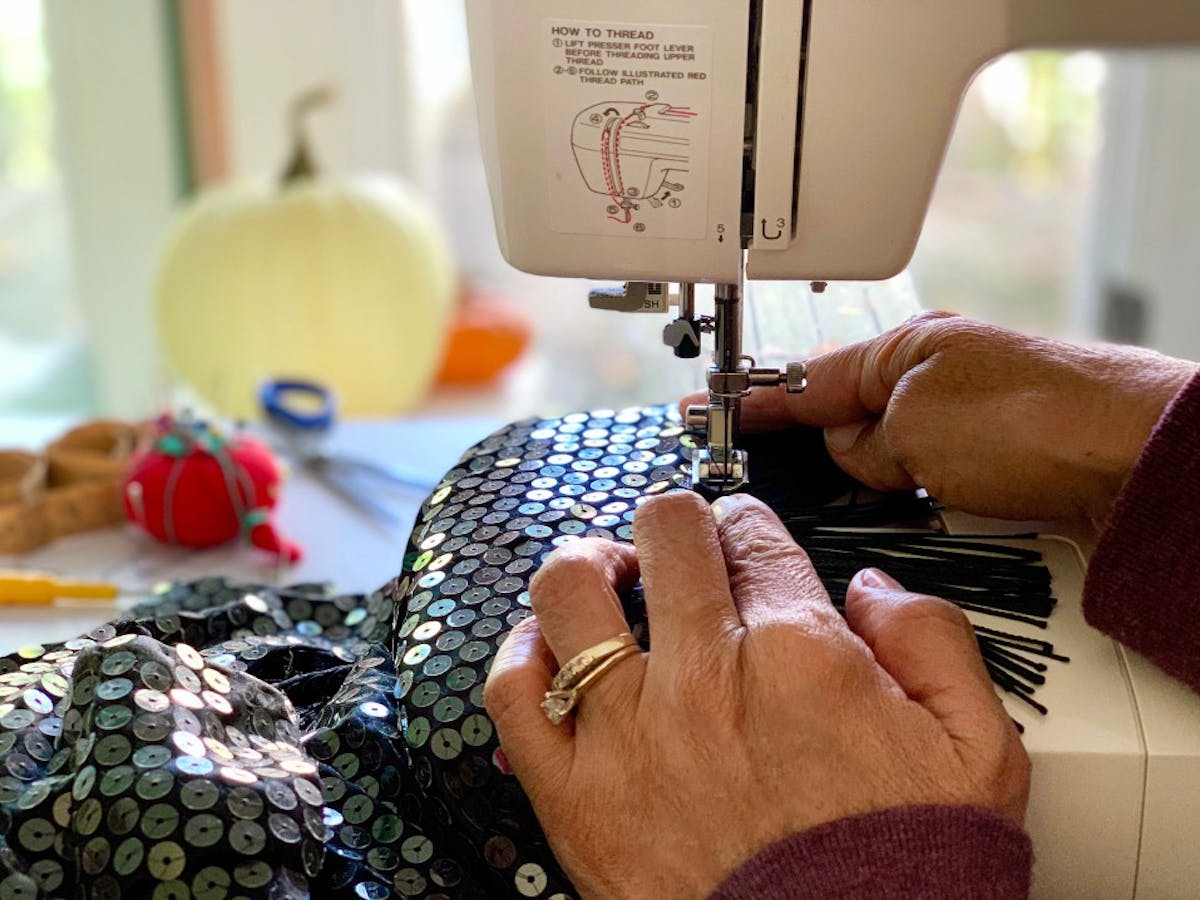 A woman sewing a flapper costume