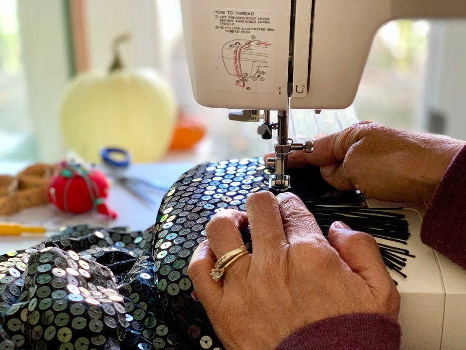 A woman sewing a flapper costume A woman sewing a flapper costume