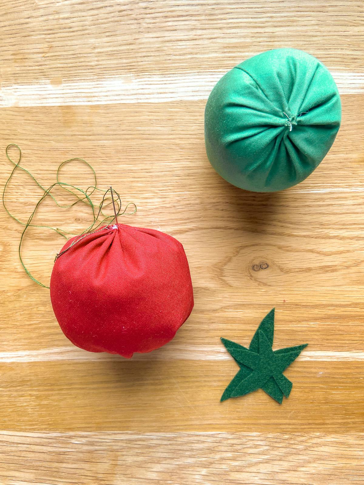 Rifinitura del portaspilli fai da te a forma di pomodoro in rosso e verde. Aggiunta dei sepali Rifinitura del portaspilli fai da te a forma di pomodoro in rosso e verde. Aggiunta dei sepali