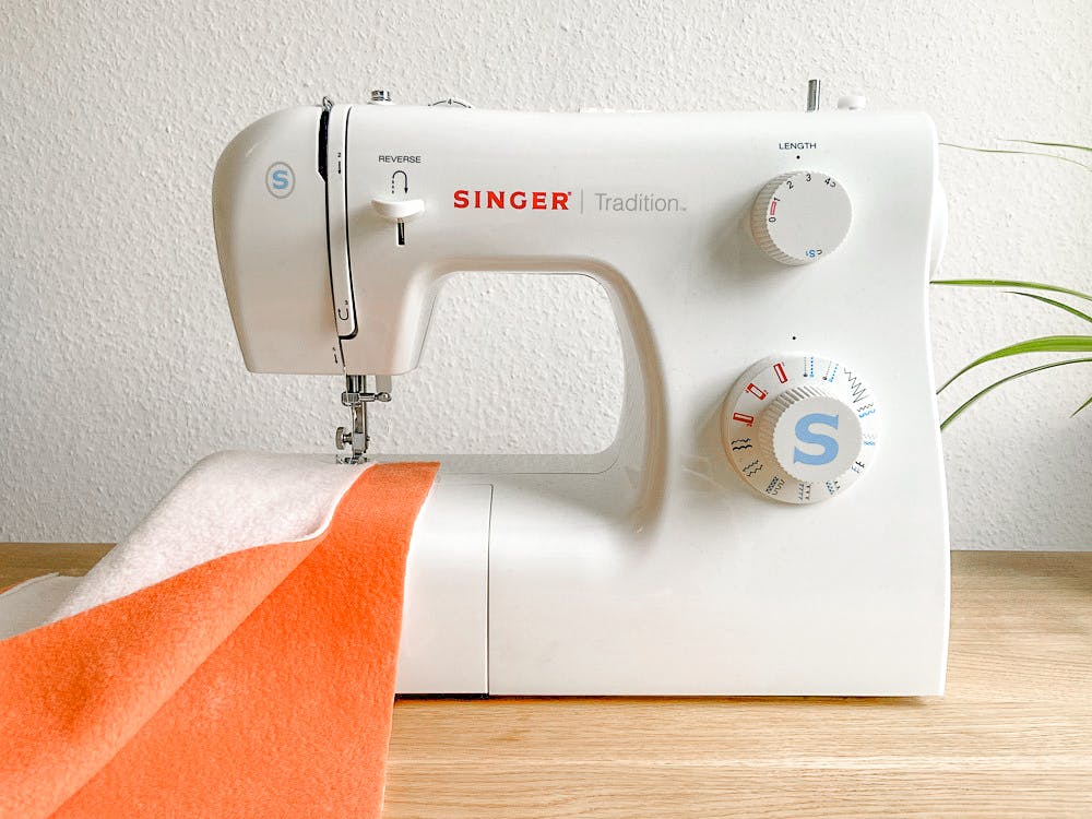  Máquina de coser y tela de felpa de color naranja