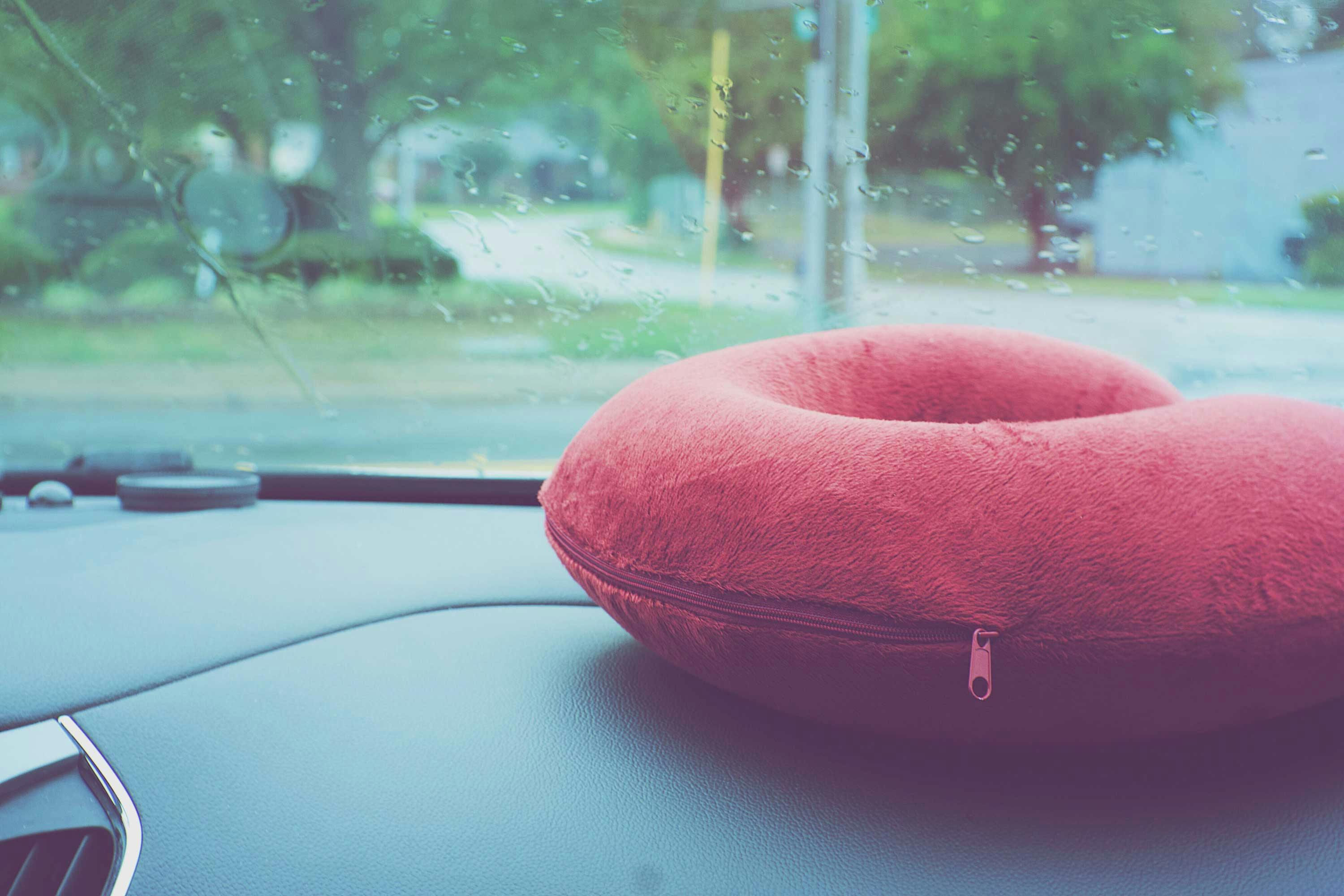  red travel pillow on dashboard of car