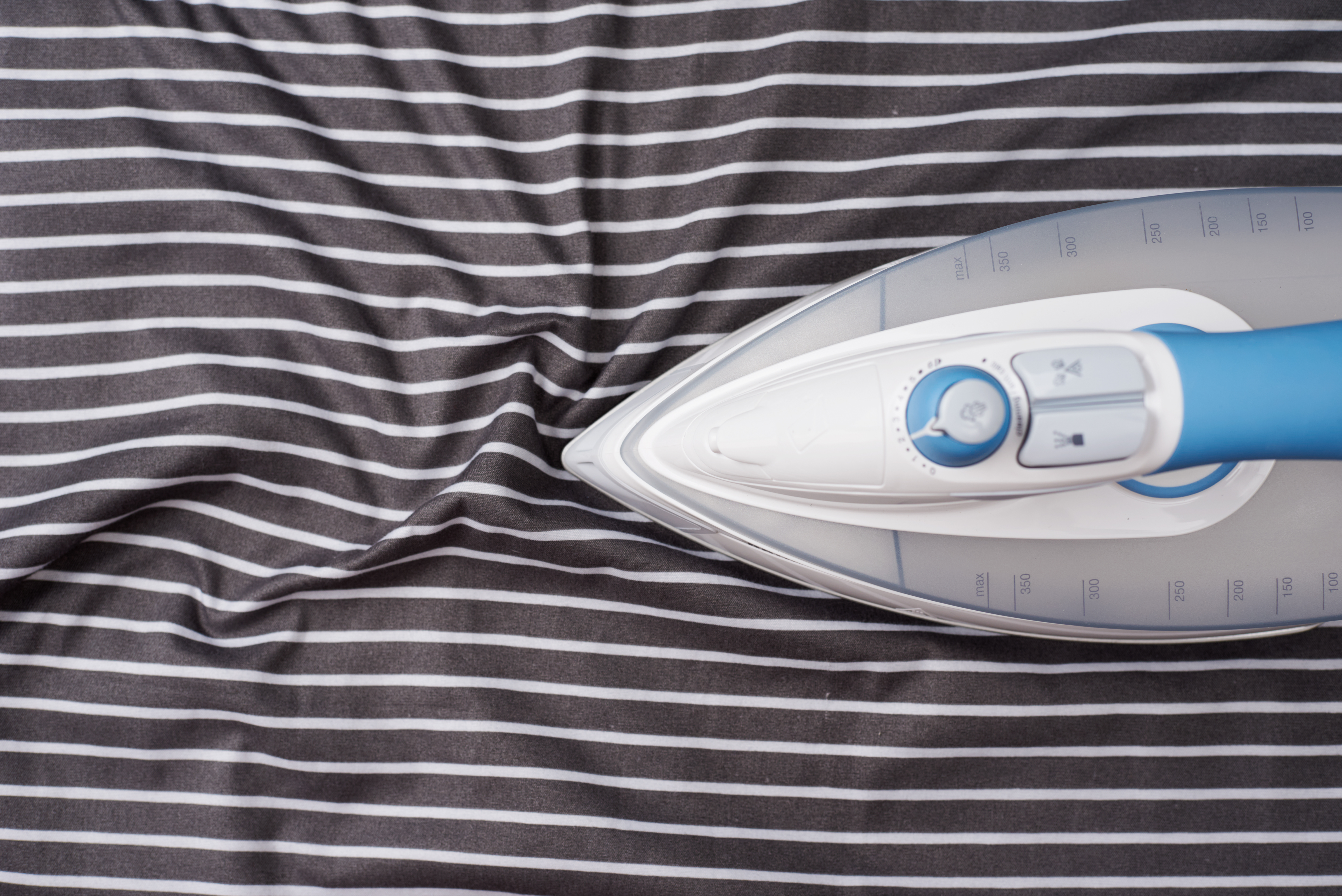 top down view of iron on striped fabric