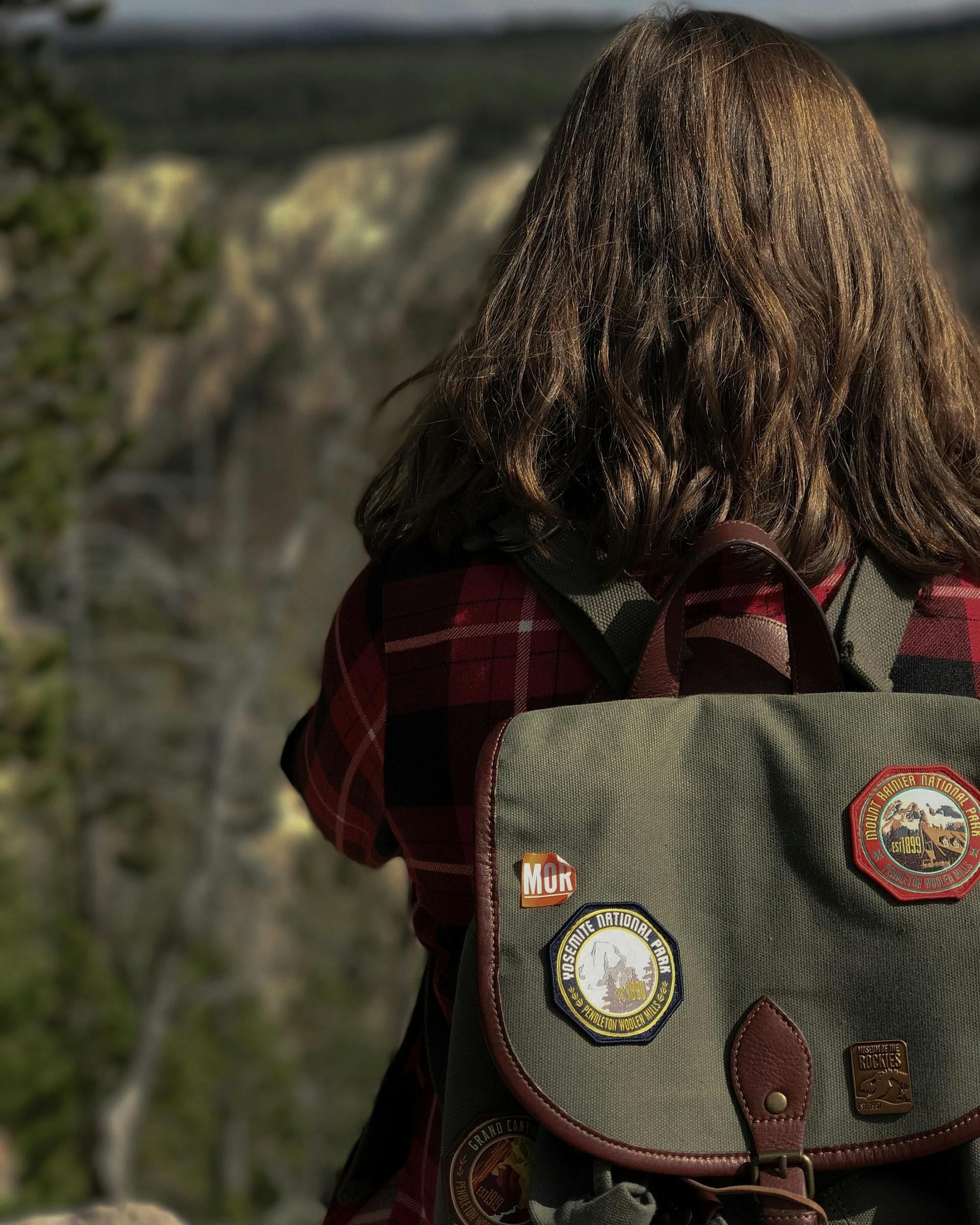  woman&#039;s outdoors backpack covered in fabric patches