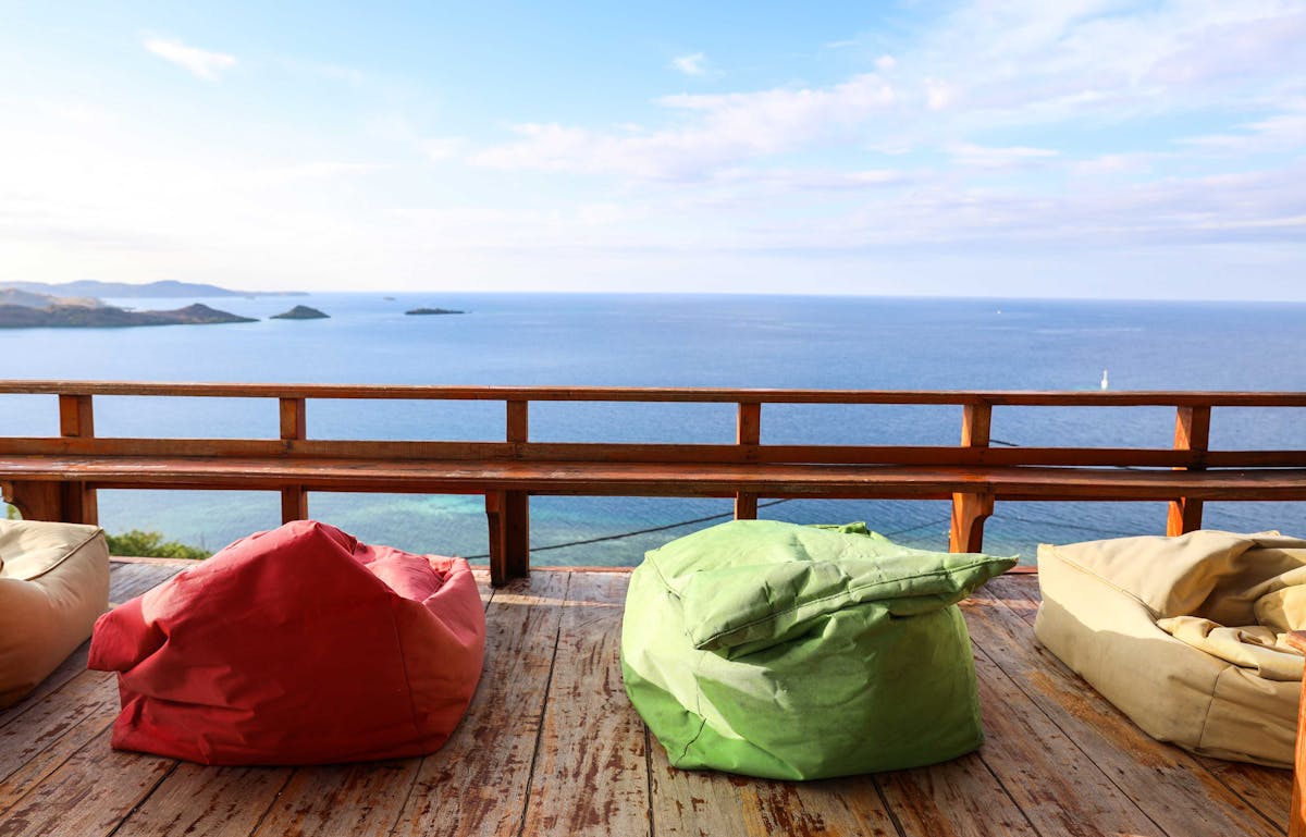  colourful outdoor beanbags on a deck with the ocean behind