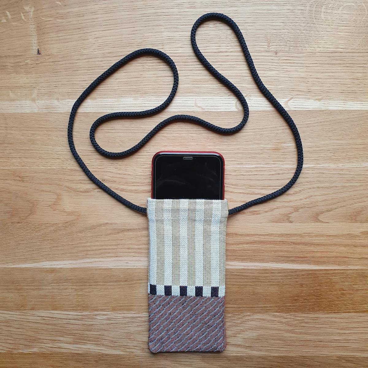  homemade iPhone Sleeve in woven striped fabric with neck cord and phone inside