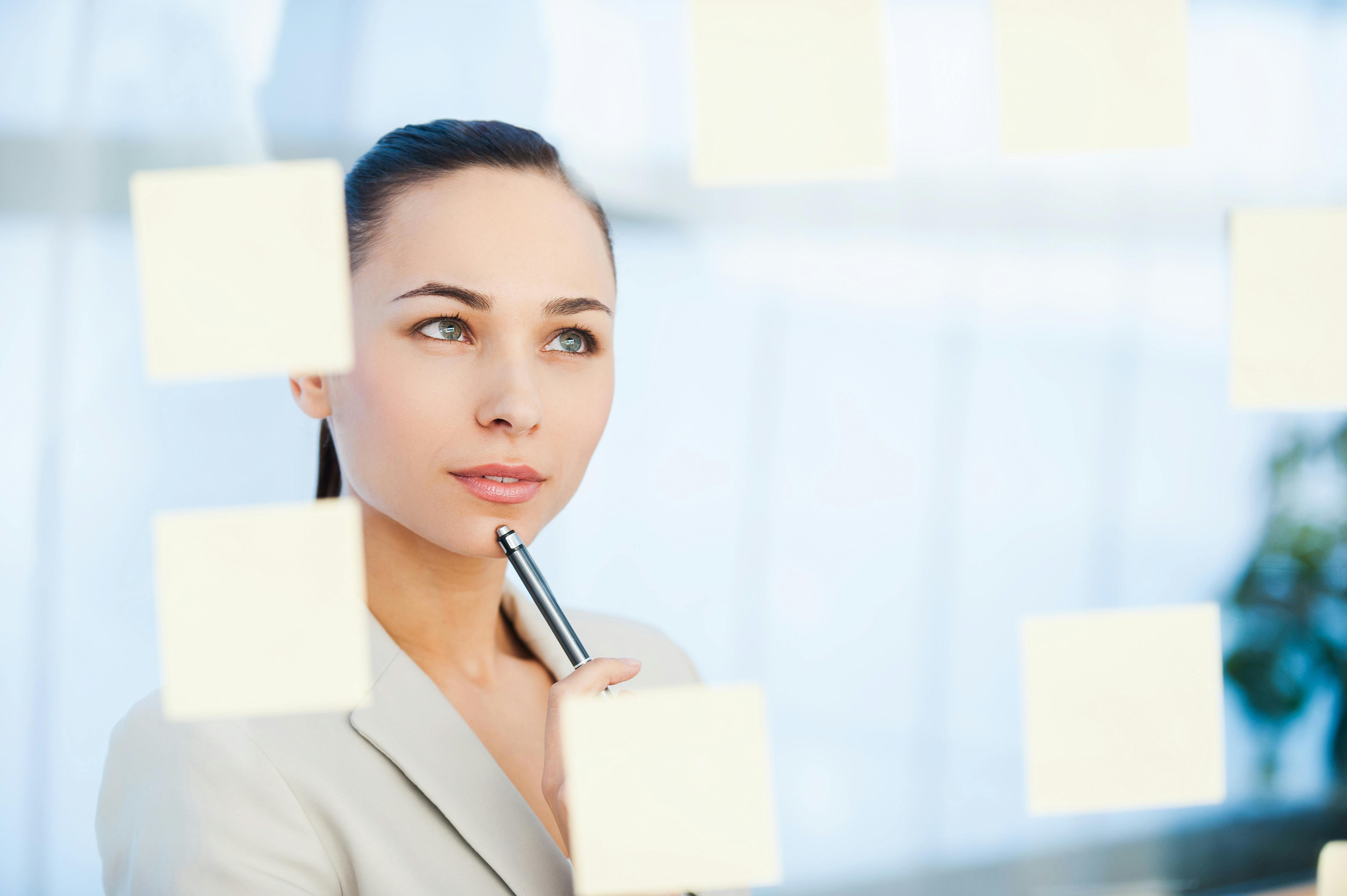  woman reading sticky notes in a business office setting