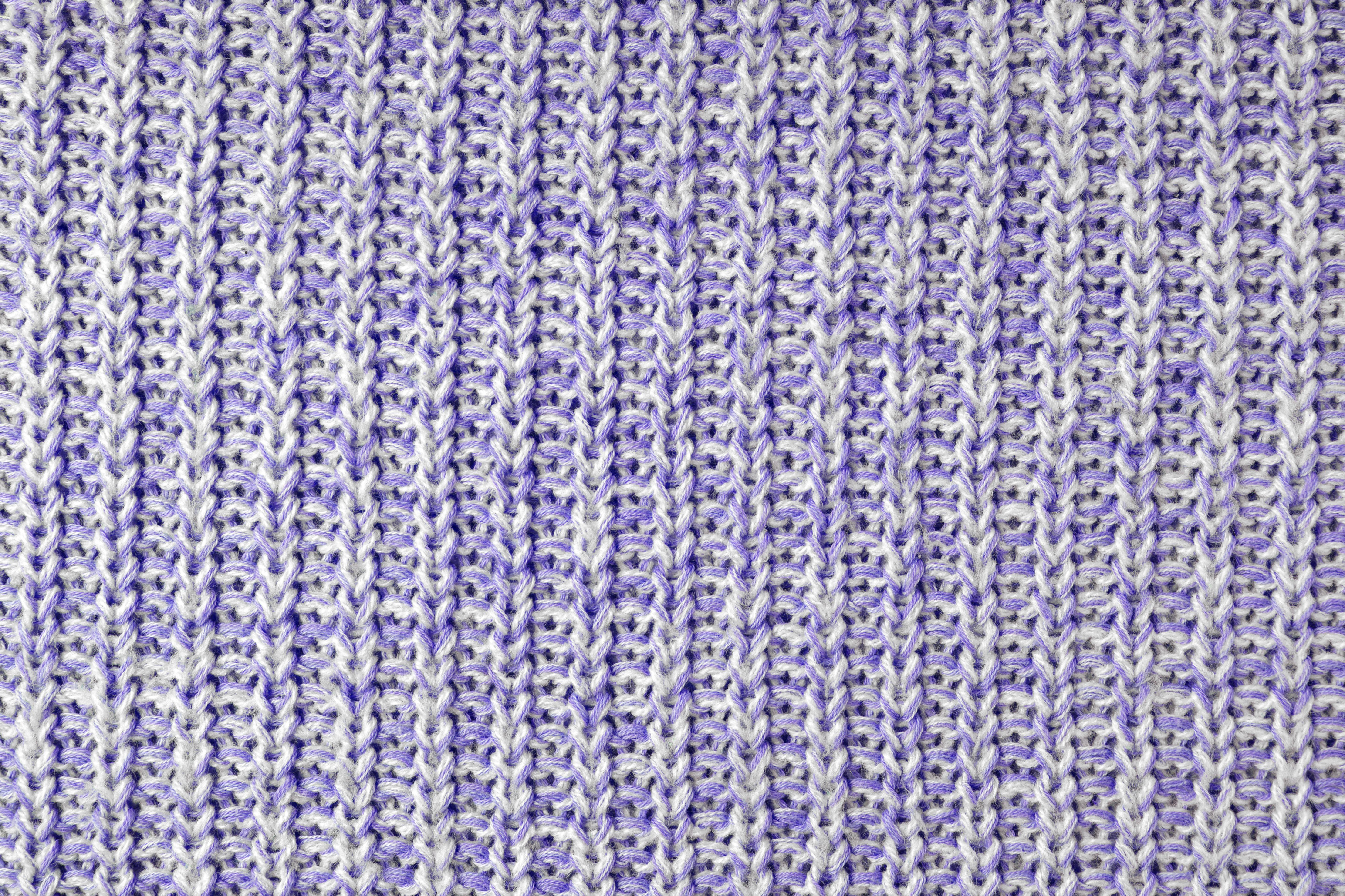  close up of knitted fabric in a purple and white melange pattern