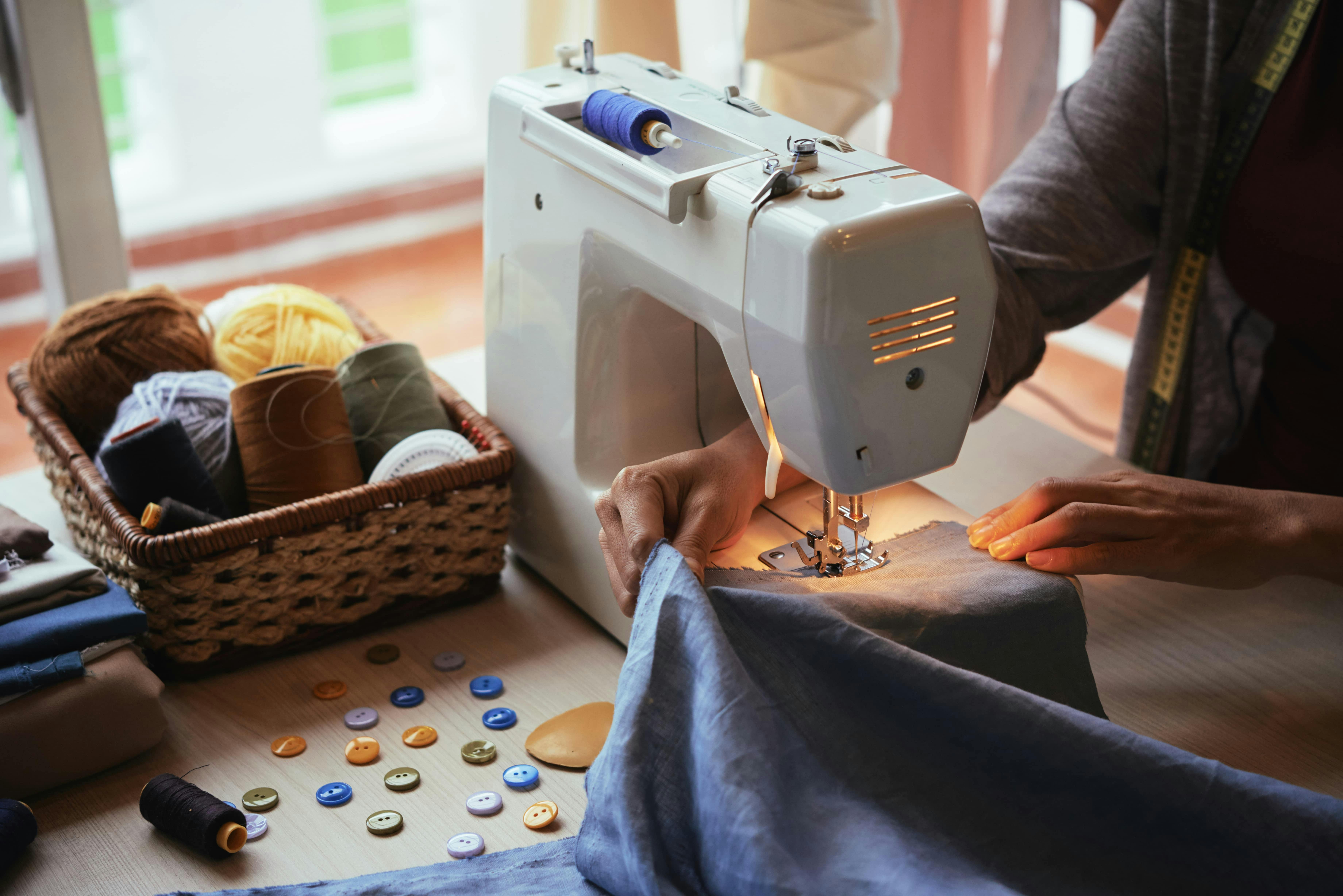  Image of person practicing sewing techniques using sewing machine with buttons and thread laid out
