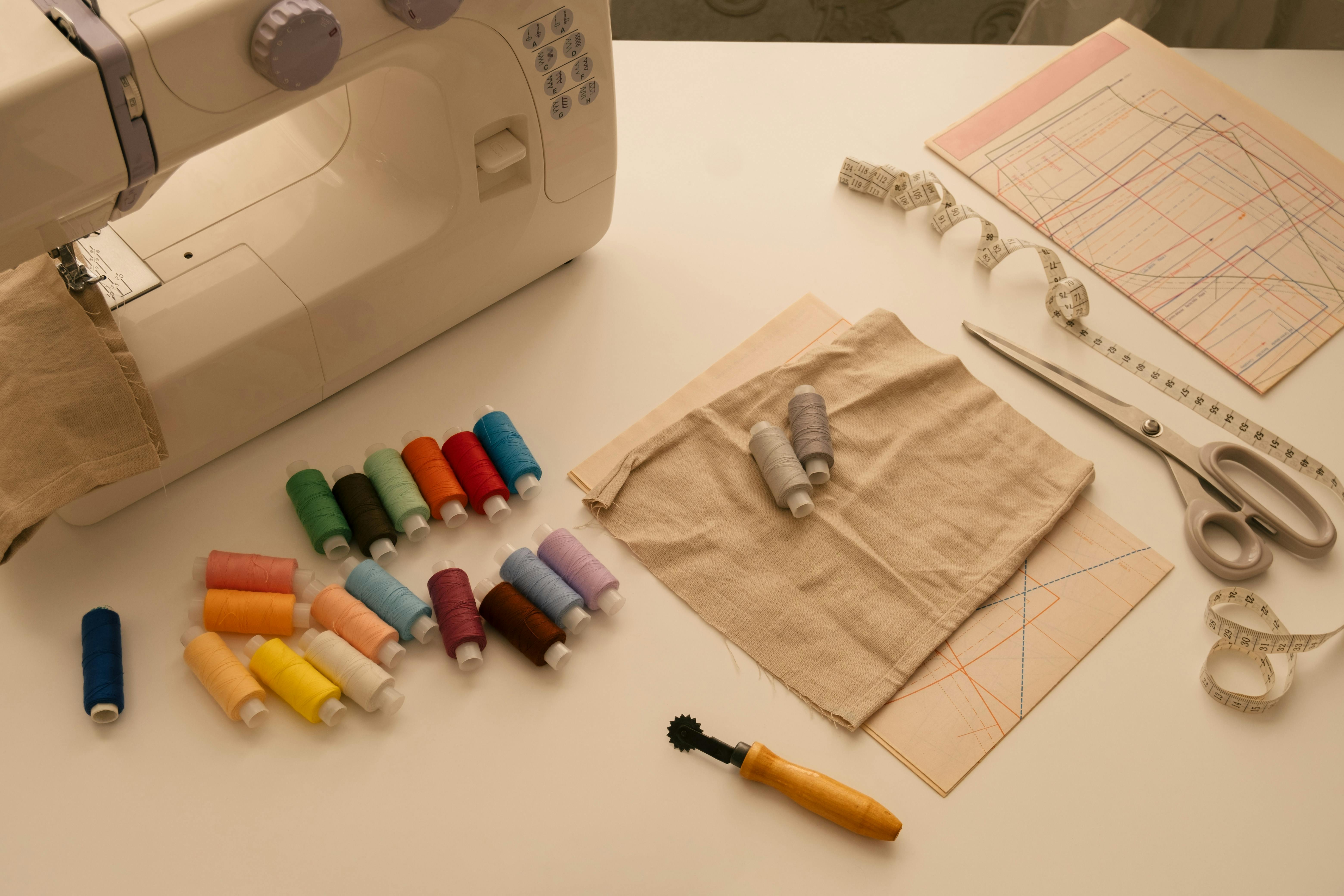  photo of sewing machine with sewing tools like thread and scissors
