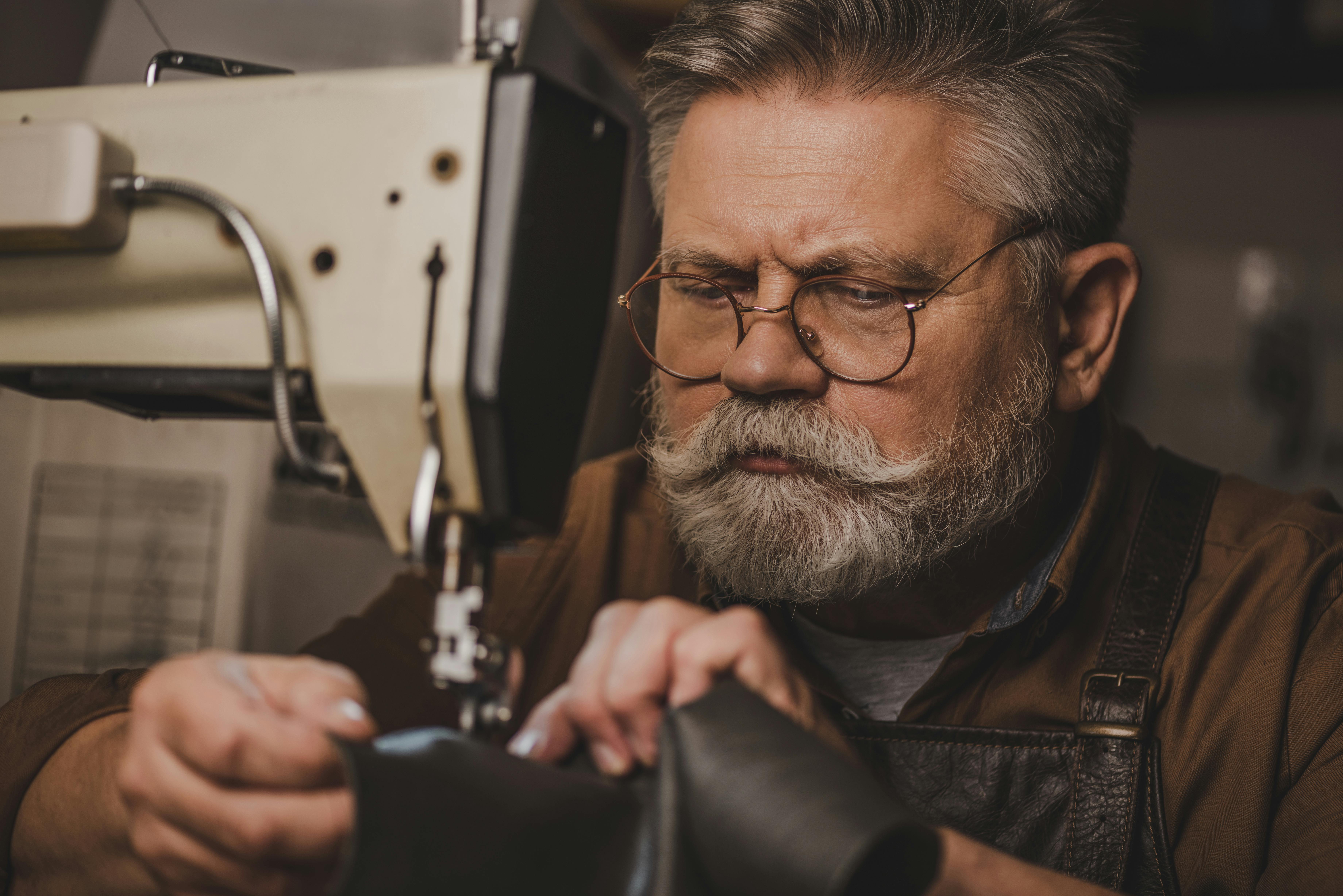  man looking close up at sewing machine