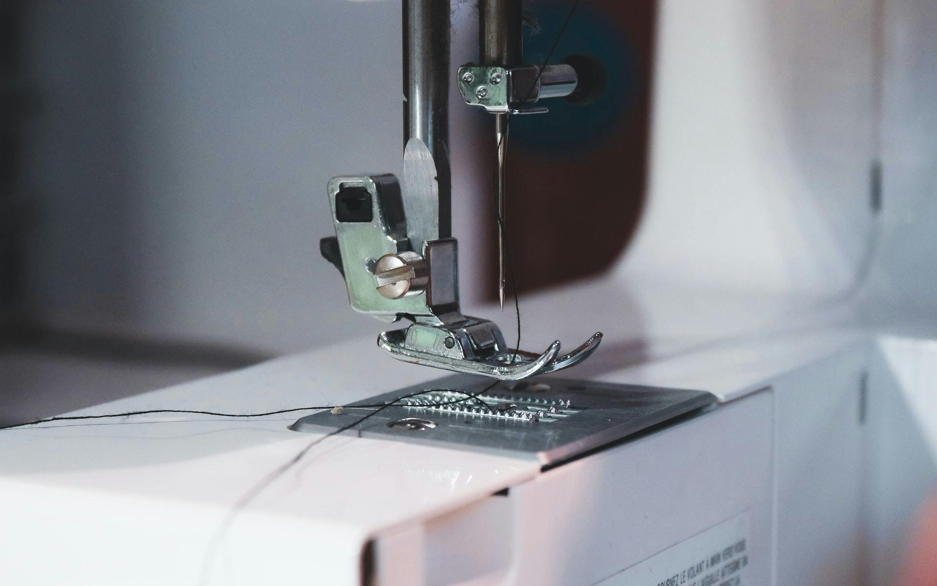  close up of sewing machine foot with black thread