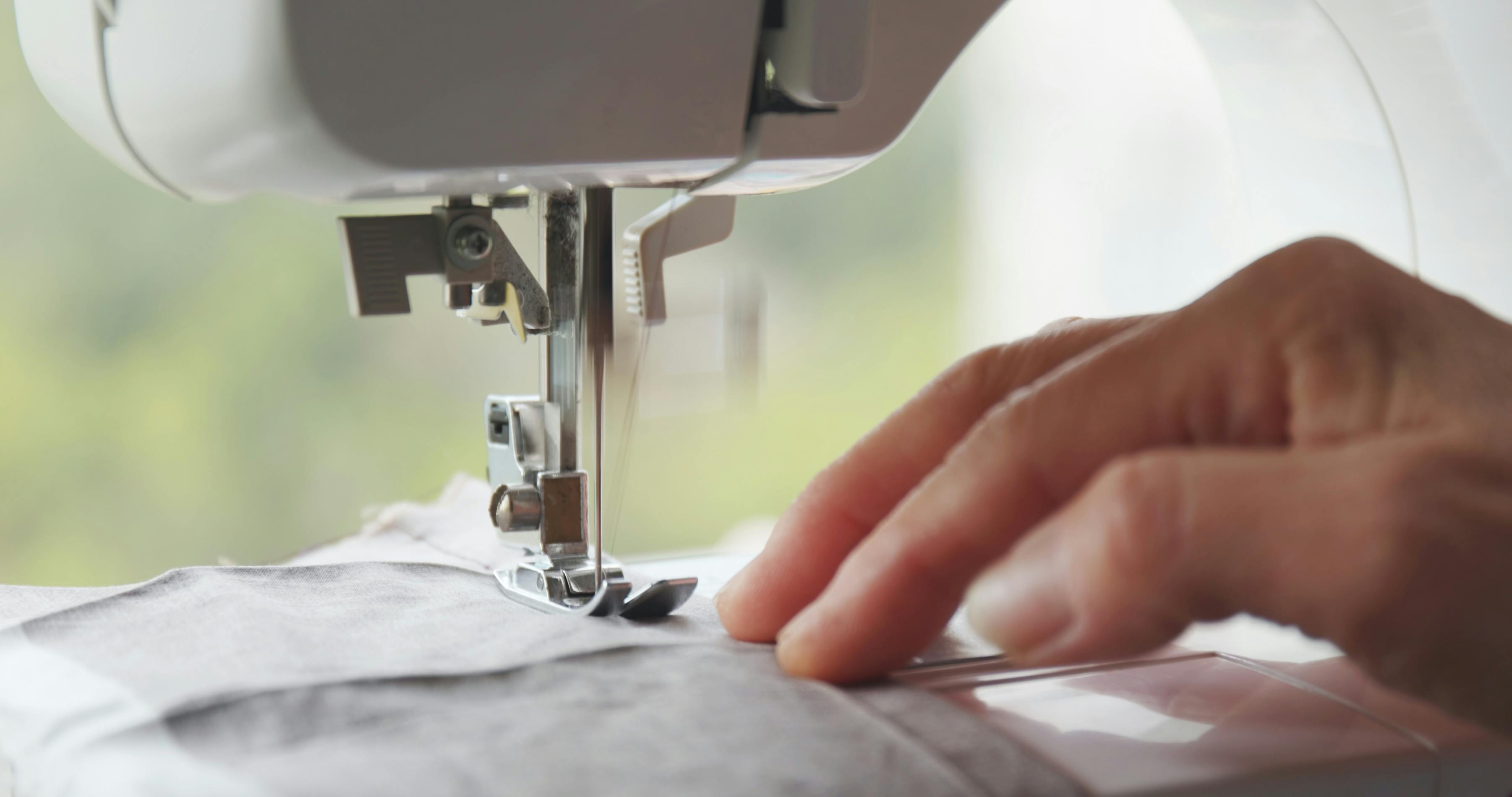  hand guiding fabric through sewing machine