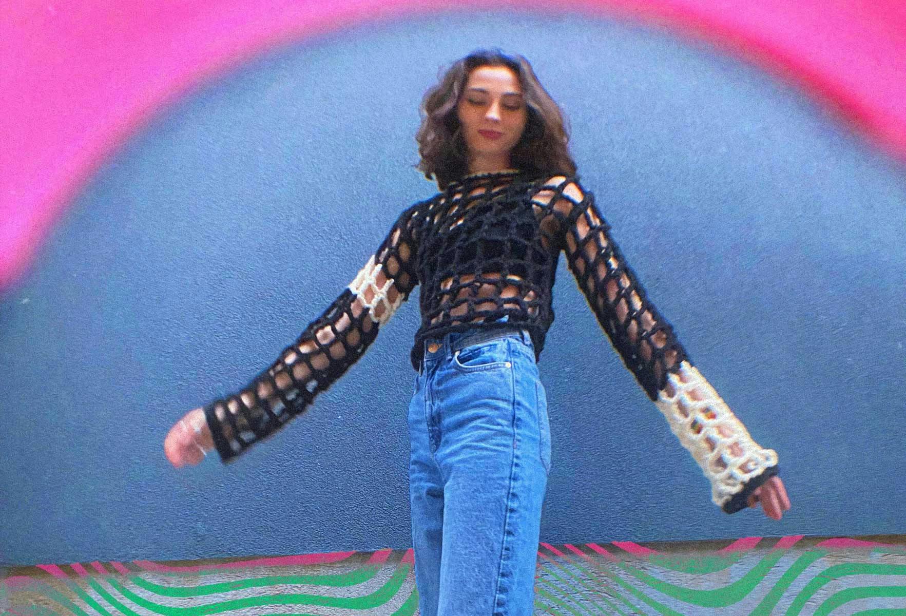  girl wearing long sleeve crochet pullover against colourful background