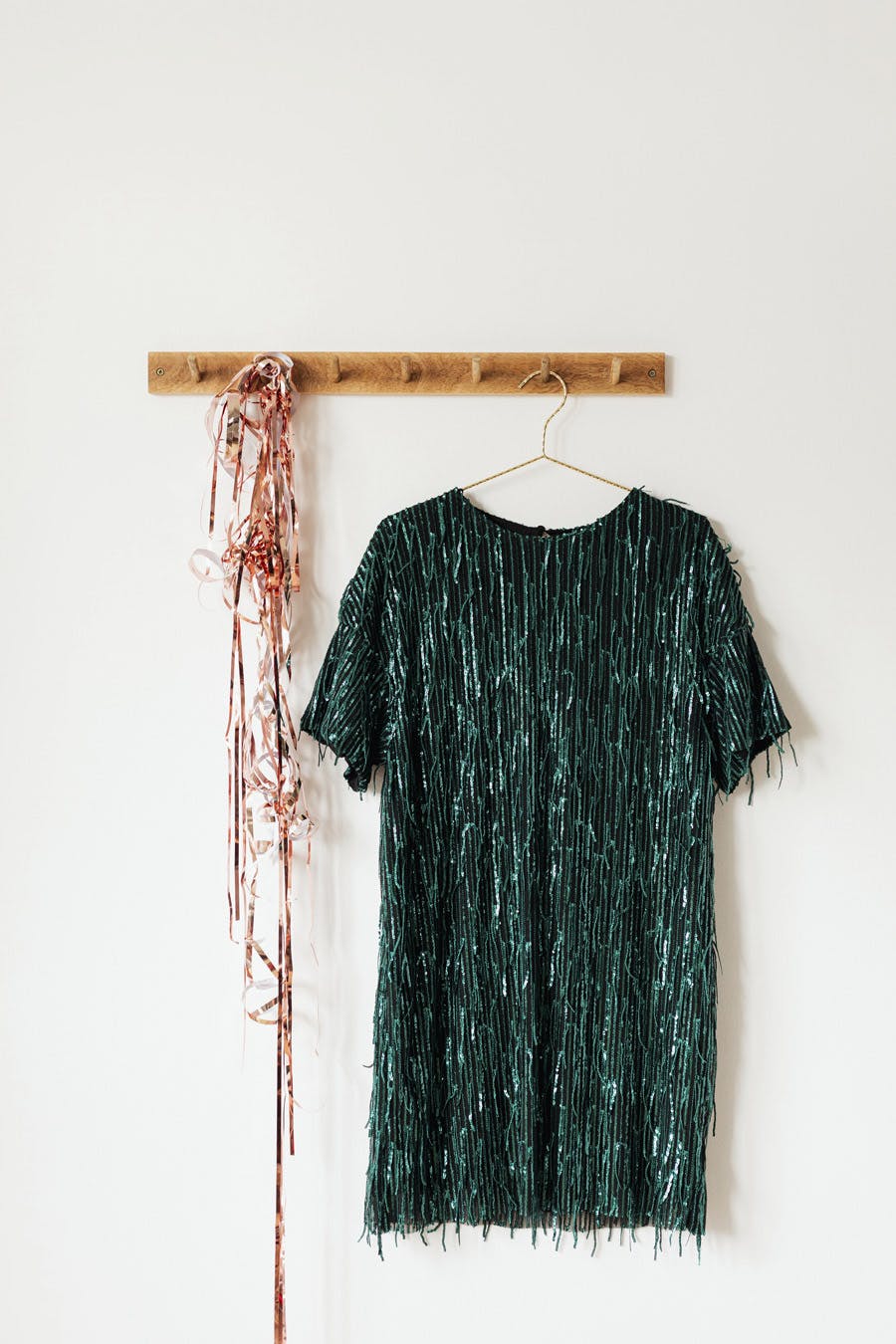  photo of dark green sequin dress hanging on a wall