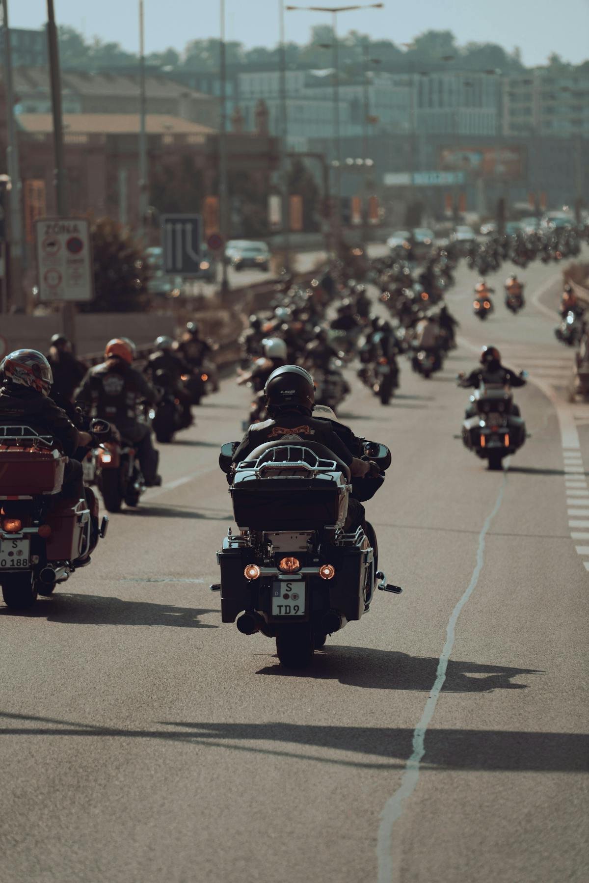 A large group of motorcyclists riding together on a city road A large group of motorcyclists riding together on a city road