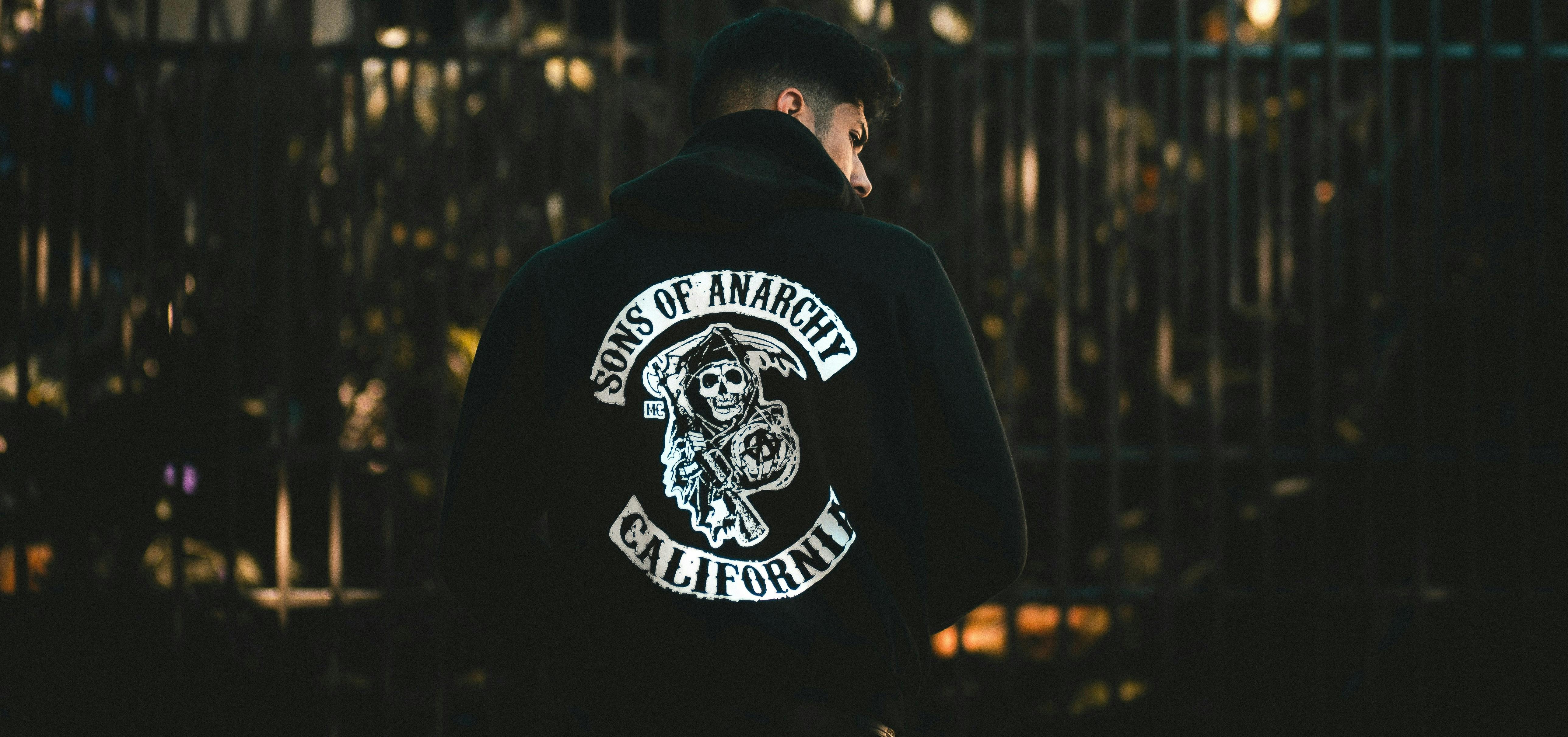  A man wearing a black hoodie with a large Sons of Anarchy patch on the back