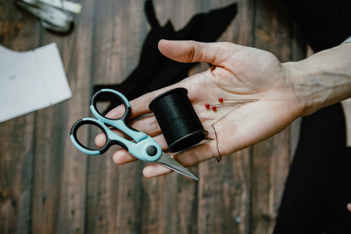 A close-up of a person's hand holding sewing essentials A close-up of a person's hand holding sewing essentials