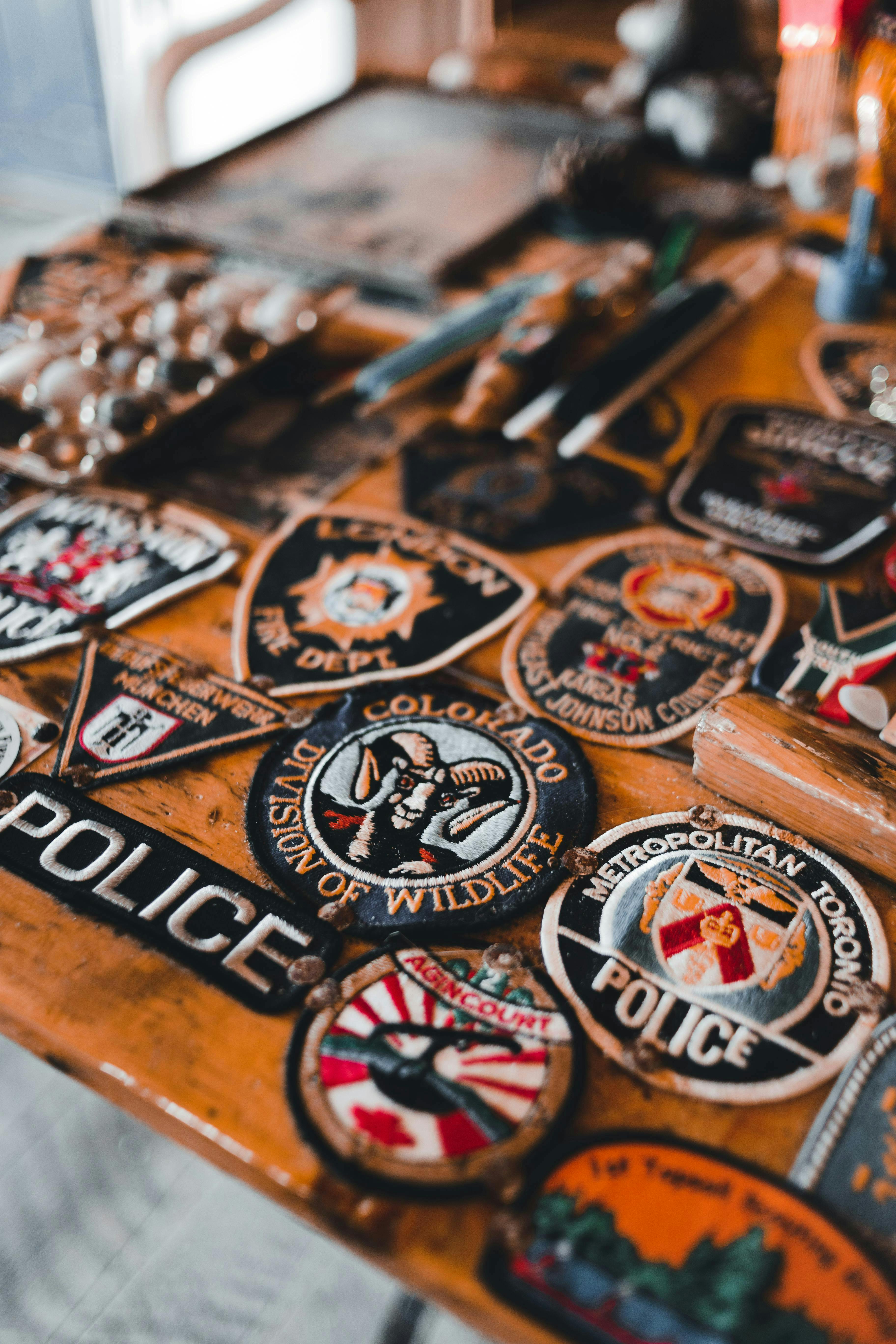 a collection of mainly police patches laying on a table a collection of mainly police patches laying on a table