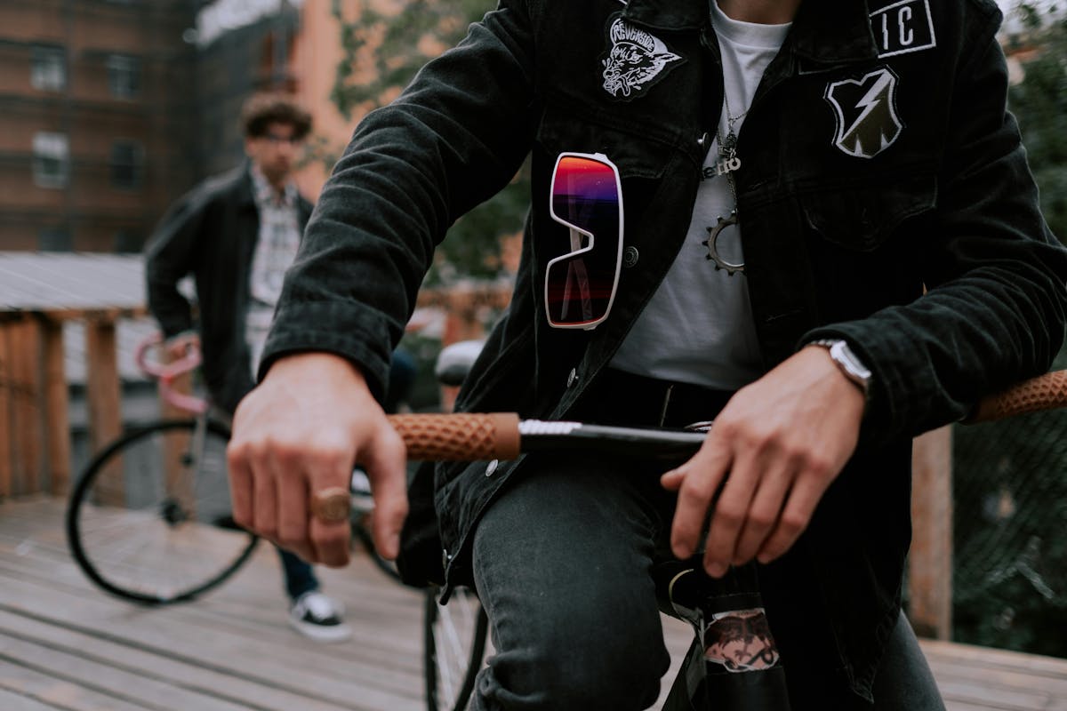 a guy sitting on a bike, wearing a jacket with patches on it   a guy sitting on a bike, wearing a jacket with patches on it